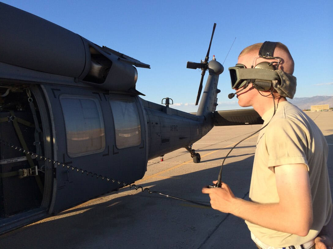 Airman 1st Class Michael Kramer, an HH-60G Pave Hawk tactical aircraft maintainer with the 943rd Rescue Group, Davis-Monthan Air Force Base, Ariz., stays connected with the crew members of an HH-60G while prepping the aircraft for an exercise June 19, 2014.  Tactical aircraft maintainers, more commonly known as "crew chiefs," coordinate the aircraft's maintenance and call in specialists when a problem is found. (U.S. Air Force photo/2nd Lt. Anna-Marie Wyant)