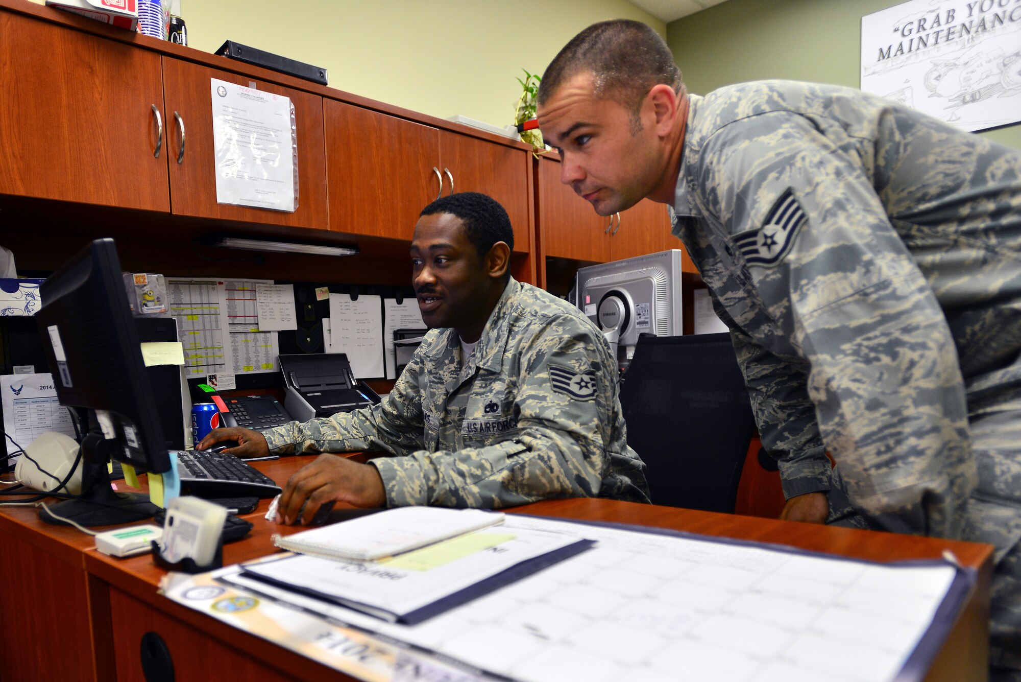 Staff Sgt. Arthur Hinojos, 22nd Aircraft Maintenance Squadron flying crew chief manager (left), reviews a tasking with Staff Sgt. Ryan Hart, 22nd AMXS safety representative (right), June 16, 2014, McConnell Air Force Base, Kan. Hinojos was selected as the spotlight performer for the week of June 15 through 21. (U.S. Air Force photo/Senior Airman Trevor Rhynes)