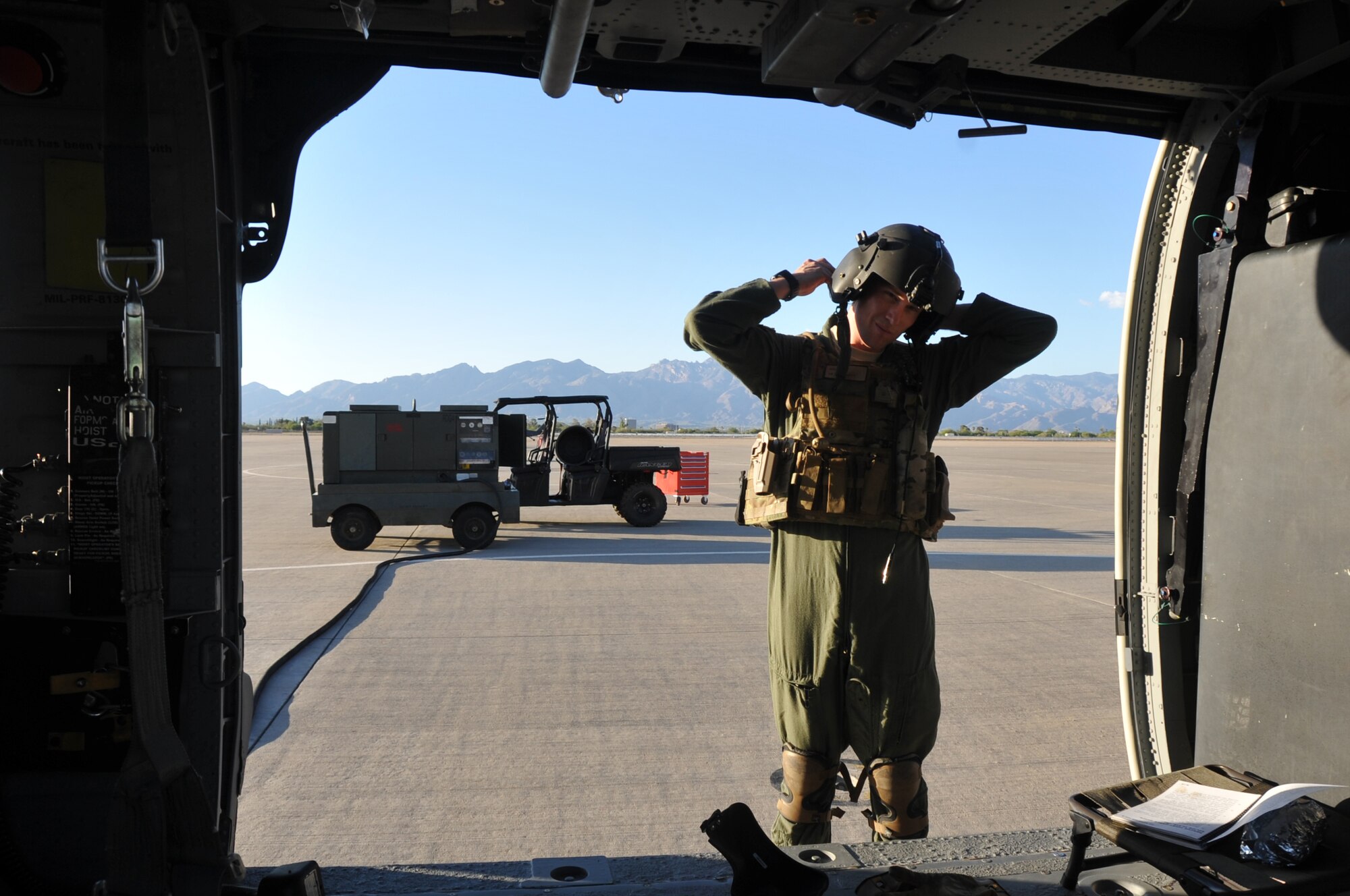 Tech. Sgt. Caleb Hiner, a special missions aviator with the 305th Rescue Squadron, Davis-Monthan Air Force Base, Ariz., fastens his helmet on prior to flying on an HH-60G Pave Hawk helicopter June 19, 2014. Hiner and four other crewmembers were preparing for an air-refueling exercise. (U.S. Air Force photo/Senior Airman Natasha Dowridge)