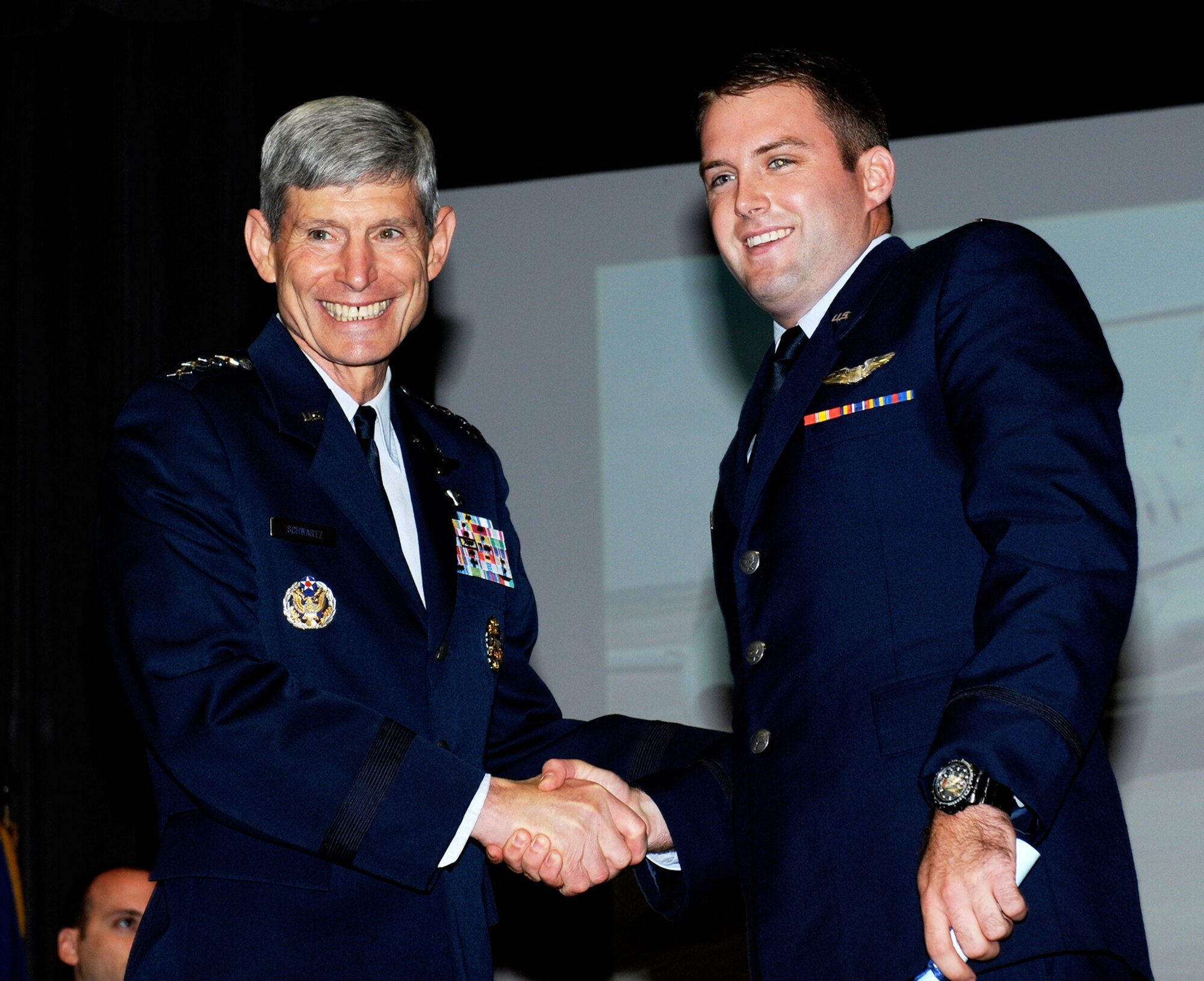 Retired Gen. Schwartz, Former Chief of Staff of the Air Force, shakes the hand of 2nd Lt. Patrick Wheble, 14th Student Squadron, at the graduation ceremony of Specialized Undergraduate Pilot Training Class 14-10 June 13, at the Kaye Auditorium on Columbus Air Force Base. Wheble is the godson of Schwartz’ wife. (U.S. Air Force photo/ Melissa Doublin)