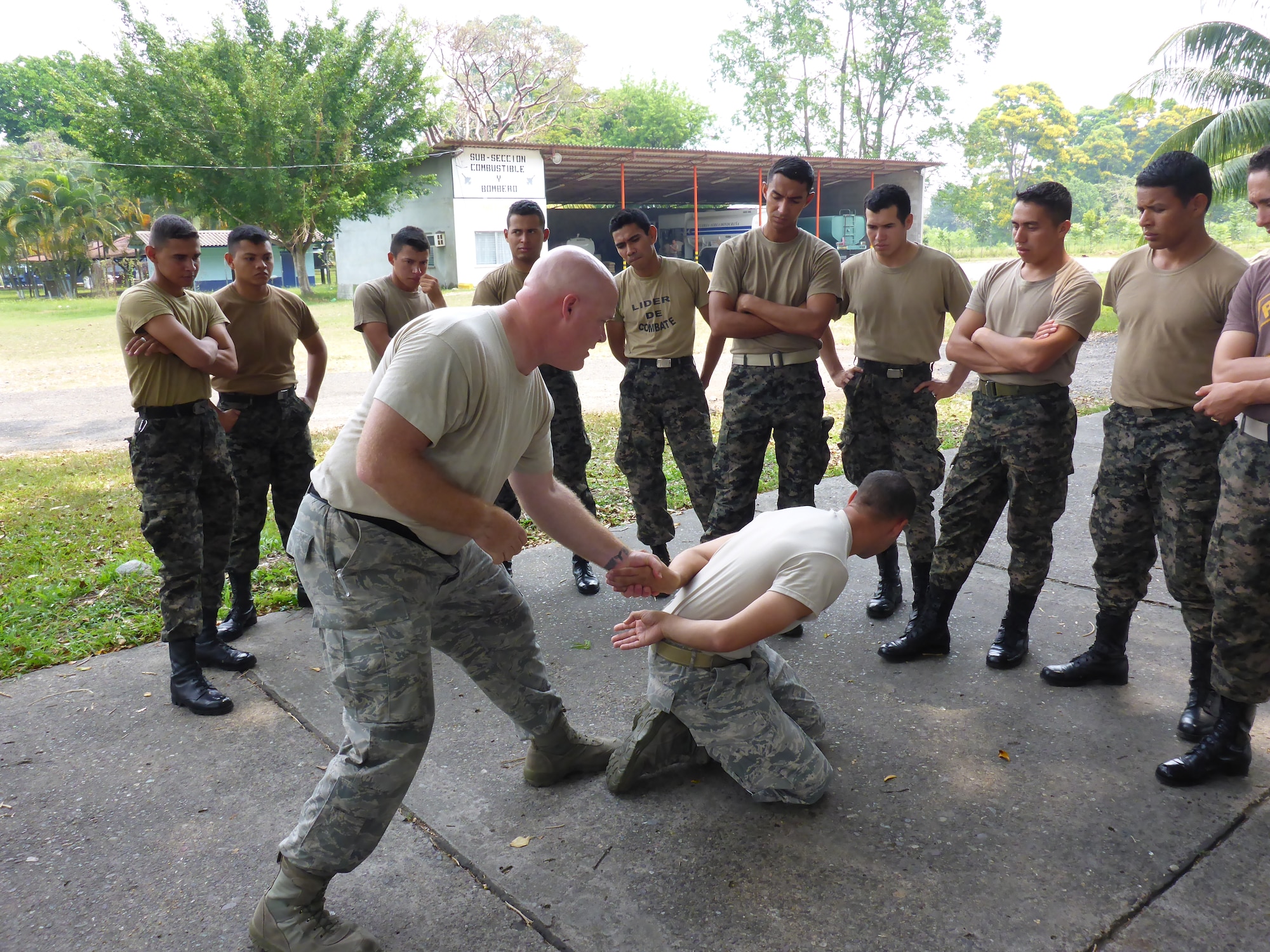 Master Sgt. Marc Slonecker and Tech. Sgt. Edgar Gonzalez, 571st Mobility Support Advisory Squadron security forces air advisers, demostrate restraint techniques earlier this year for members of the Honduran air force security team during an MSAS Building Partnership Capacity mission at Hector Caraccioli Moncada Air Base, Honduras. (U.S. Air Force photo/Capt. Elizabeth Peters)
