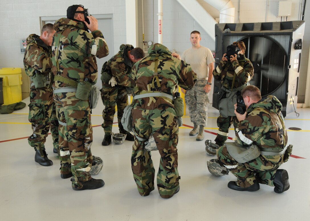 U.S. Air Force Staff Sgt. Mathew Eaves supervises fellow airmen as they transition from Mopp 2 to Mopp 4 during CBRNE survival skills training on the Mississippi Combat Readiness Training Center, Gulfport, Miss., June 18, 2014.  Eaves instructed airmen on the proper use and wear of the chemical suit. (U.S. Air Force photo by Senior Airman Jessica Fielder/Released)