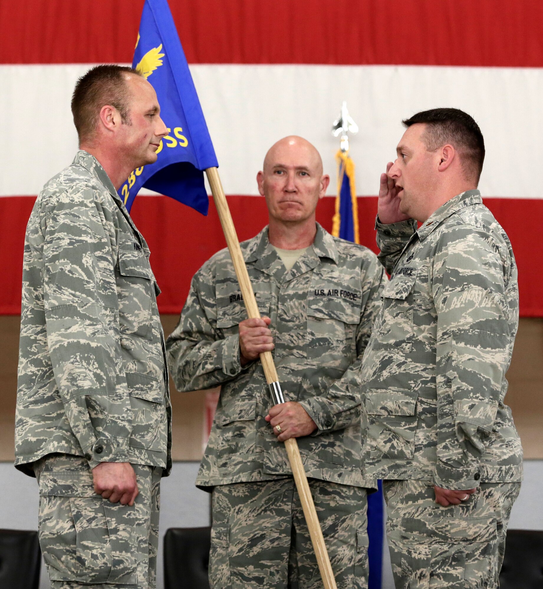 Maj. Paul Needham assumes command of the 288th Operations Support Squadron from Lt. Col. Robert Kinney, 188th Intelligence, Surveillance and Reconnaissance Group commander, left, as Command Chief Master Sgt. Stephen Bradley, 188th Wing command chief master sergeant, looks on. Needham assumed command of the 288th OSS during the 188th Wing’s Conversion Day ceremony which recognized the many changes occurring at the wing as a result of its conversion to a remotely piloted aircraft (MQ-9 Reapers) and intelligence, surveillance and reconnaissance mission. The 188th Fighter Wing was also redesignated as the 188th Wing during the event. (U.S. Air National Guard photo by Master Sgt. Mark Moore)
