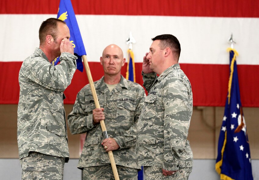 Maj. Paul Needham assumes command of the 288th Operations Support Squadron from Lt. Col. Robert Kinney, 188th Intelligence, Surveillance and Reconnaissance Group commander, left, as Command Chief Master Sgt. Stephen Bradley, 188th Wing command chief master sergeant, looks on. Needham assumed command of the 288th OSS during the 188th Wing’s Conversion Day ceremony which recognized the many changes occurring at the wing as a result of its conversion to a remotely piloted aircraft (MQ-9 Reapers) and intelligence, surveillance and reconnaissance mission. The 188th Fighter Wing was also redesignated as the 188th Wing during the event. (U.S. Air National Guard photo by Master Sgt. Mark Moore)