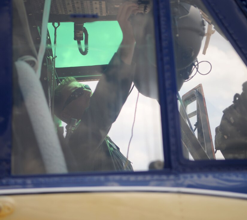 Staff Sgt. Mark Cornett, 1st Helicopter Squadron special missions aviator instructor, inspects the overhead dials on a UH-1N Huey helicopter on Joint Base Andrews, Md., June 17, 2014. (U.S. Air Force photo/Airman 1st Class Ryan J. Sonnier)