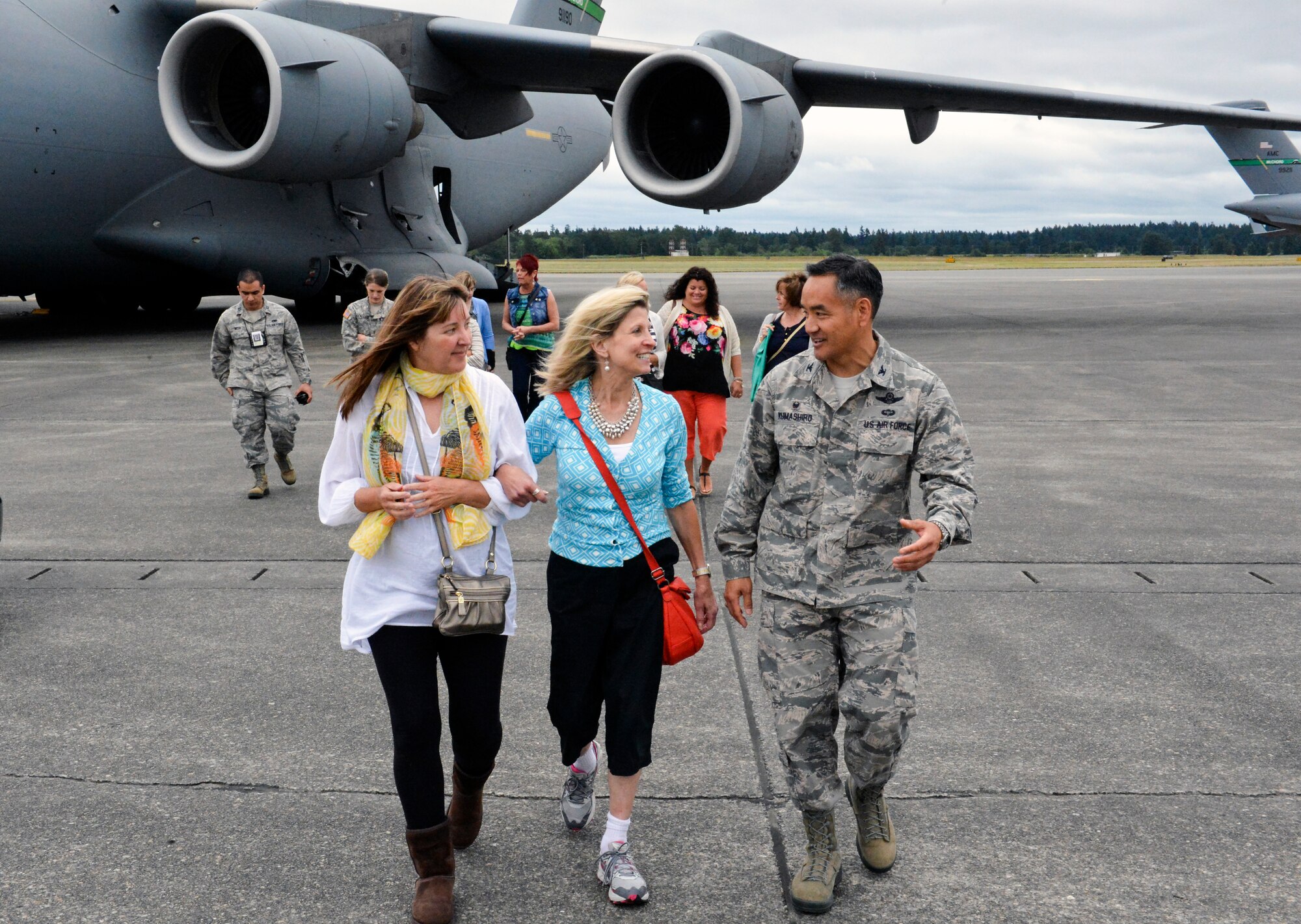 Col. David Kumashiro, 62nd Airlift Wing commander, escorts Madeline Lanza (center) and Christy Shields (left) back to the McChord Field passenger terminal after a tour of a C-17 Globemaster III aircraft June 12, 2014, at Joint Base Lewis-McChord, Wash. The I Corps Team of senior spouses met to discuss leadership as it pertains to senior spouses as leaders and advisors within their respective organization amongst other issues. (U.S. Air Force photo/Staff Sgt. Russ Jackson)