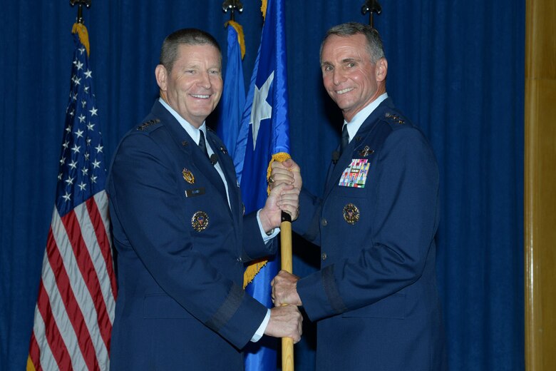 Gen. Robin Rand, commander of Air Education and Training Command, hands Lt. Gen. Tony Rock the three star flag during a promotion ceremony at Joint Base San Antonio-Randolph, Texas, June 19. Rock, a San Antonio native, will move on to be Chief, Office of the Defense Representative-Pakistan, at the U.S. Embassy in Islamabad, Pakistan. (U.S. Air Force photo/Joel Martinez)