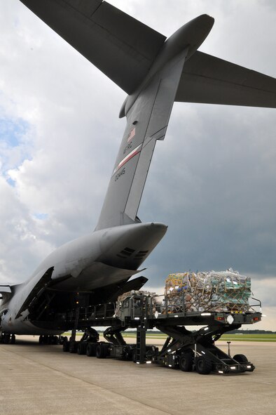 YOUNGSTOWN AIR RESERVE STATION, Ohio – Members of the Air Force Reserve 910th Airlift Wing’s 76th Aerial Port Squadron (APS) move cargo from a pair of K-Loader ground cargo transport vehicles to a waiting C-5 Galaxy strategic cargo transport aircraft on the flightline here, June 13, 2014. The “Port Dawgs,” as Aerial Port Squadrons are nicknamed throughout the Air Force, are moving part of more than 30 tons of humanitarian cargo from the vehicles to the aircraft. The cargo is being flown to a pediatric hospice in Guatemala as part of the Denton program, which allows non-governmental organizations to utilize military airlift to move their humanitarian cargos to those who need it. U.S. Air Force photo by Master Sgt. Bob Barko Jr.