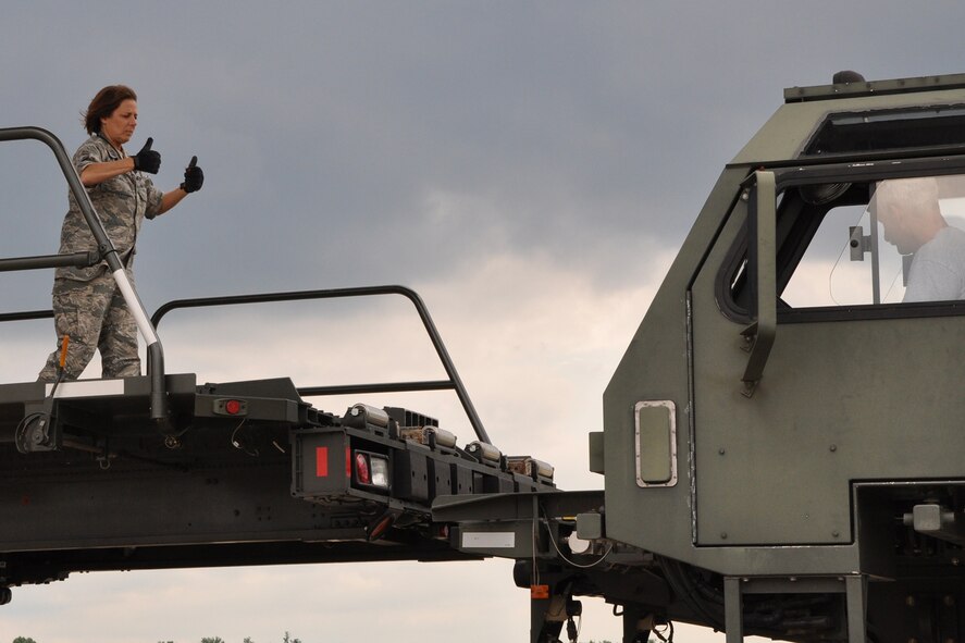 YOUNGSTOWN AIR RESERVE STATION, Ohio – Air Force Reserve Master Sgt. Christine Feliciano, an air delivery maintainer assigned to the 910th Airlift Wing’s 76th Aerial Port Squadron (APS), gives the thumbs up to the driver of a K-Loader ground cargo transport vehicle, on the flightline here, June 13, 2014. Felciano is indicating the vehicle is in position for the 76th APS team to transfer part of more than 30 tons of humanitarian cargo from the vehicle to a waiting C-5 Galaxy strategic cargo transport aircraft. The cargo is being flown to a pediatric hospice in Guatemala as part of the Denton program, which allows non-governmental organizations to utilize military airlift to move their humanitarian cargos to those who need it. U.S. Air Force photo by Master Sgt. Bob Barko Jr.