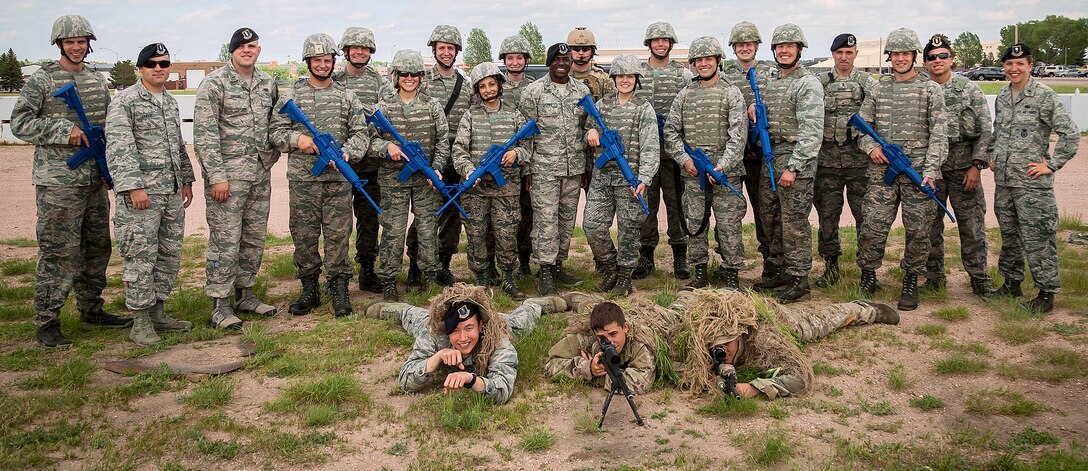 Company Grade Officers from a variety of career fields participated in a 90th Security Forces Group immersion tour July 12, 2014, led by security forces CGOs, to learn about the diverse mission set the defenders execute every day at F.E. Warren Air Force Base. 90th SFG Task Response Force Airmen are posted up in the front with camouflage gear to blend into the environment for the small unit tactics practical scenario. Participants carry fake blue guns and wear heavy helmets and vests to gain a more realistic perspective of what security forces takes on day to day. 