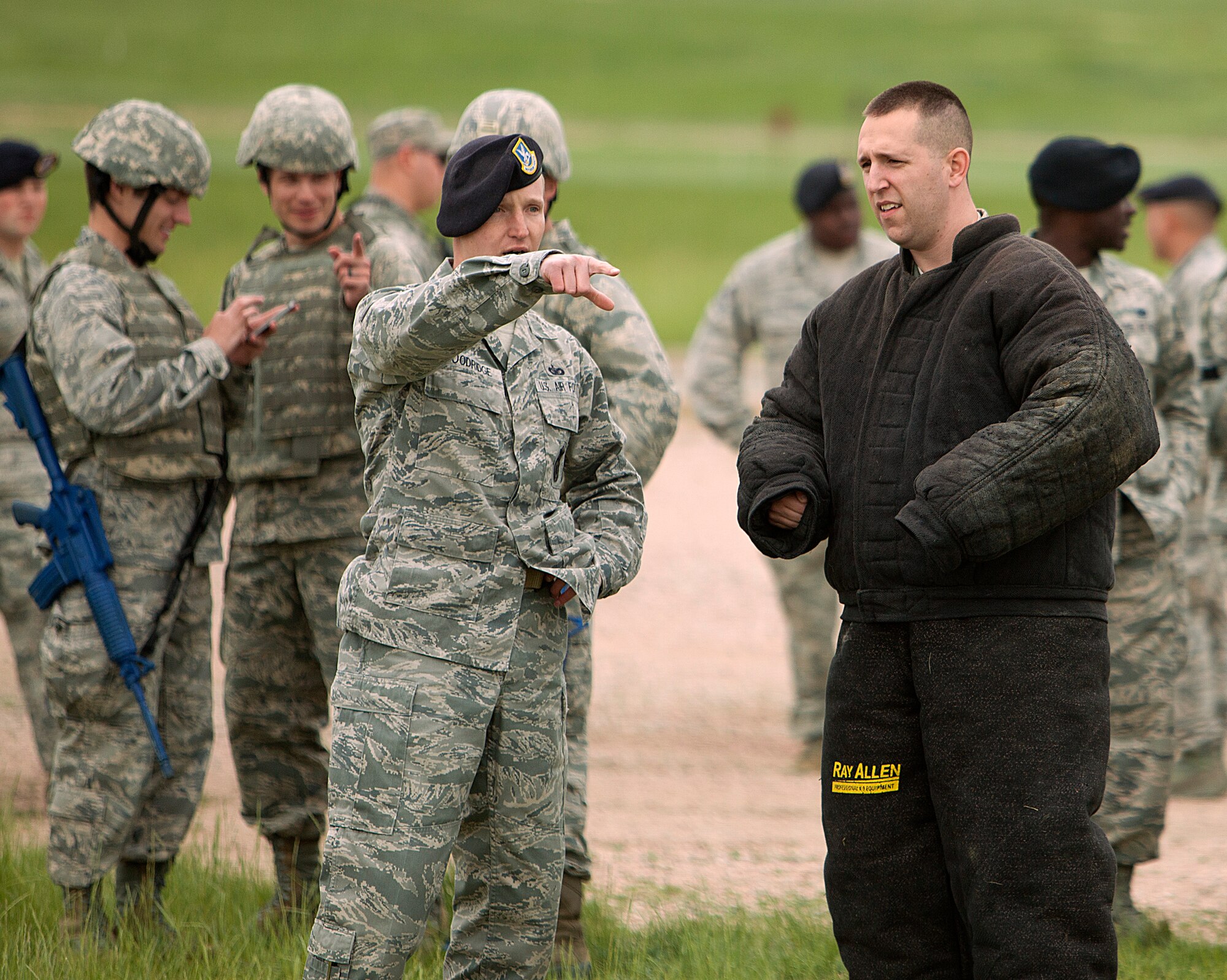 Technical Sgt. Ryan Goodridge, 90th Security Forces Squadron kennel master, explains to 2nd Lt. Nicholas Vaughn, 321st Missile Squadron, his role as the suspect in the working dog demonstration. As directed to do so for the demonstration, Vaughn did not comply with the kennel master’s request to walk forward at the sound of his voice and instead ran in the opposite direction. The master let his dog loose and bit Vaughn’s arm, protected by the bite suit. This demonstration was one of many events Company Grade Officers took part in during the Security Forces Group immersion tour June 12, 2014, on F.E. Warren Air Force Base. (Courtesy photo by 2nd Lt. Stefan Choquette)