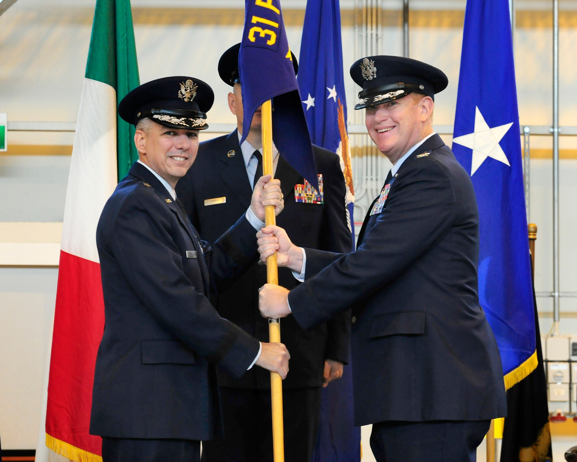 Brig. Gen. Barre Seguin, 31st Fighter Wing commander, passes the 31st Medical Group guidon to Col. J. Scott Calder, during the group’s change of command ceremony, June 20, 2014, at Aviano Air Base, Italy. Calder previously served as the 59th Medical Operations Group deputy commander at Joint Base San Antonio-Lackland Air Force Base, Texas. (U.S. Air Force photo/Airman 1st Class Ryan Conroy) 