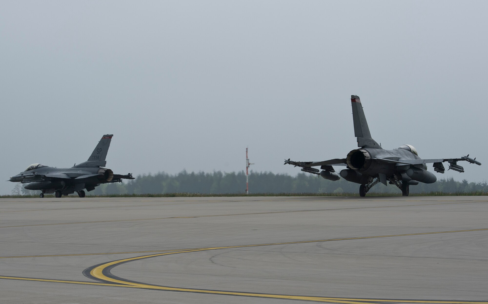 Two 480th Fighter Squadron U.S. Air Force F-16 Fighting Falcon fighter aircraft pilots taxi to the runway at Spangdahlem Air Base, Germany, before taking off for the U.S. Air Force Aviation Detachment, 52nd Operations Group, Lask Air Base, Poland, April 30, 2014. The aircraft and personnel will replace assets from the 31st Fighter Wing, Aviano Air Base, Italy, to maintain a persistent presence in the region. (U.S. Air Force photo by Staff Sgt. Chad Warren/Released)
