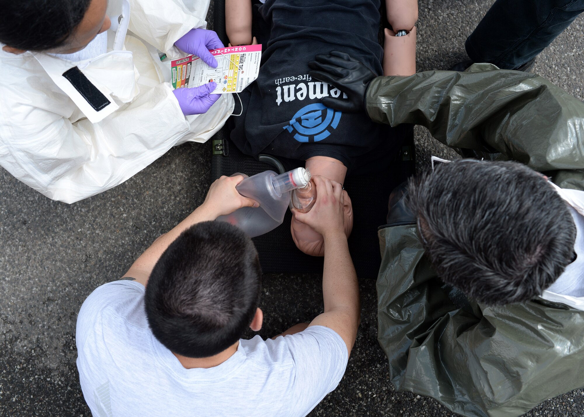 Participants of a decontamination training event evaluate a mock patient June 18, 2014, at Spangdahlem Air Base, Germany. The chart allows the medics to track the effects of contamination to gauge whether the patient is ready to enter the mobile decontamination facility. (U.S. Air Force photo by Staff Sgt. Daryl Knee/Released)