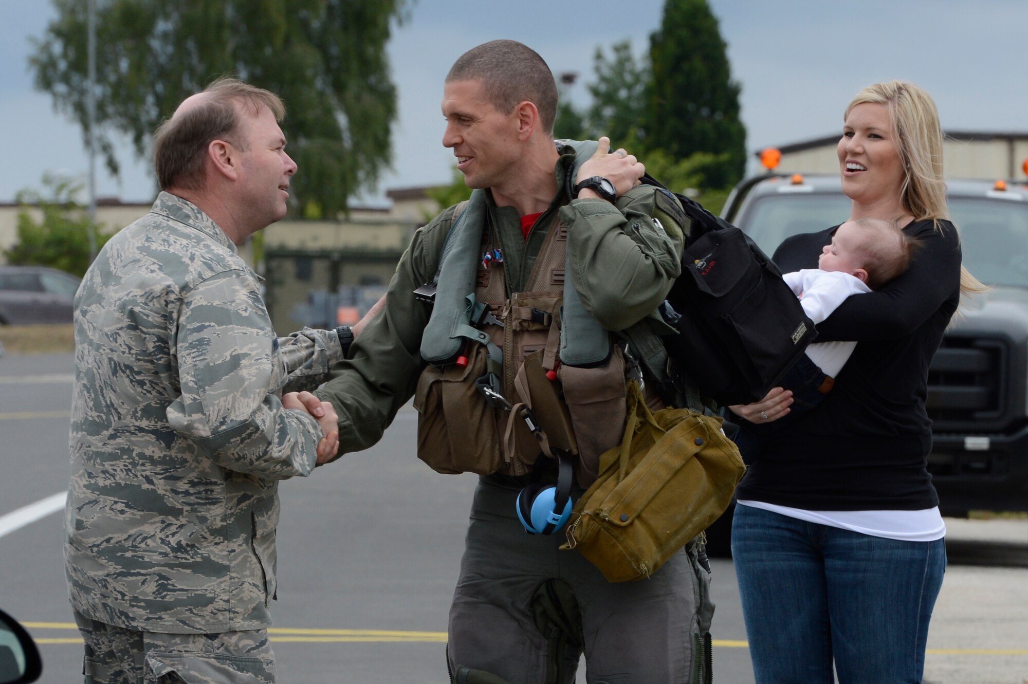 U.S. Air Force Col. Lars Hubert, acting 52nd Fighter Wing commander, welcomes home U.S. Air Force Capt. Jordan Kahn, 480th Fighter Squadron fighter pilot, with his wife Becky Kahn and son Harrison, June 20, 2014, at Spangdahlem Air Base, Germany. More than 300 U.S. Airmen supported the 480th FS at Lask Air Base, Poland. An additional 100 Airmen from the 606th Air Control Squadron provided command and control from Powidz Air Base, Poland for Exercise EAGLE TALON during Av-Det Rotation 14-3. (U.S. Air Force photo by Staff Sgt. Christopher Ruano/Released)