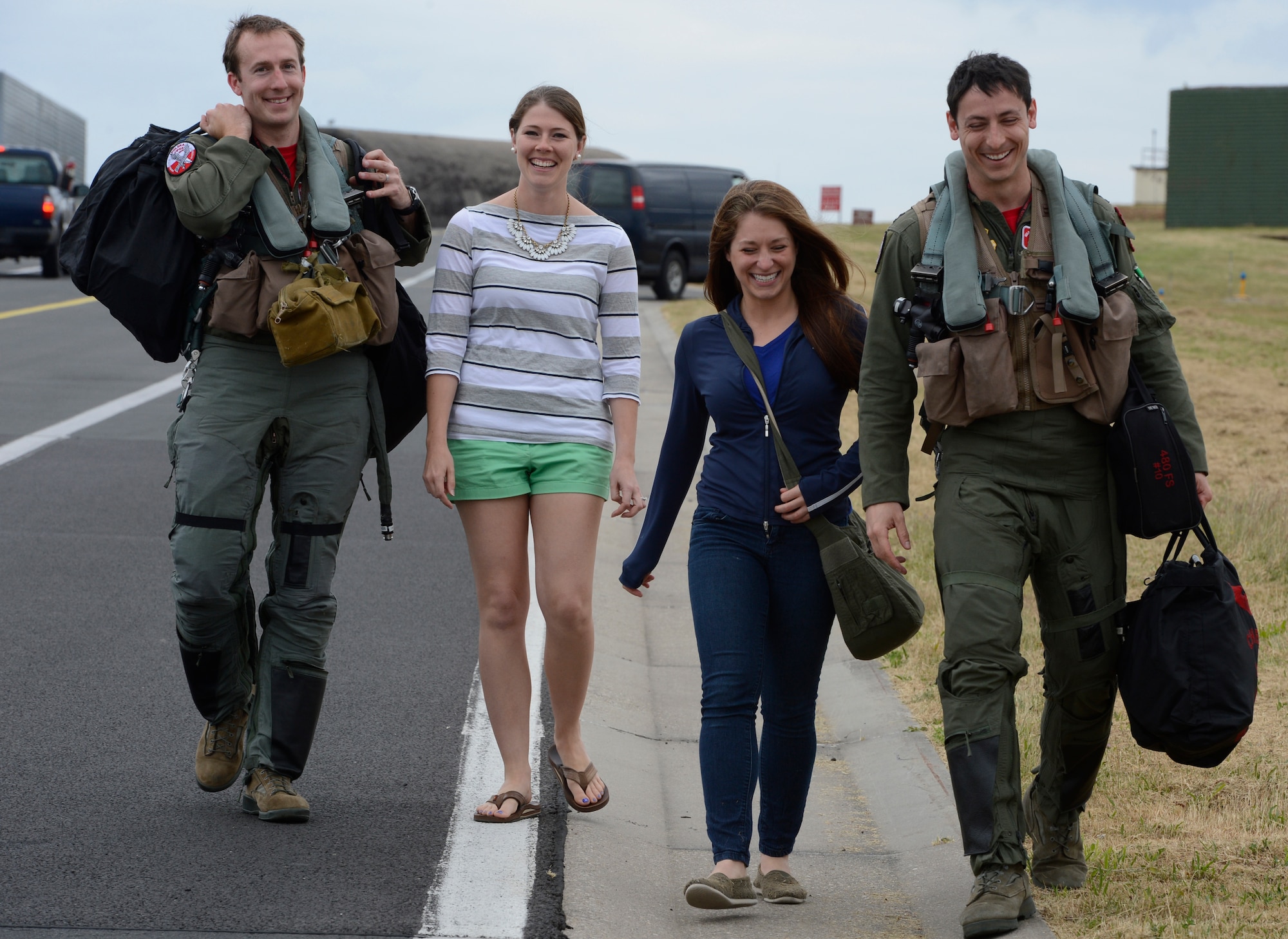 U.S. Air Force Capt. Taylor Blevins, 480th Fighter Squadron fighter pilot, with wife Tori Blevins (left) walks with U.S. Air Force Capt. Zach Shapiro, 480th Fighter Squadron fighter pilot, and wife Beth Shapiro on the flight line after returning from Poland, June 20, 2014, at Spangdahlem Air Base, Germany. U.S. Airmen flew and trained with allies in U.S. Navy-led Baltic Operations 14 and Polish-led Exercise EAGLE TALON throughout June during U.S. Aviation Detachment Rotation 14-3, Lask Air Base, Poland. (U.S. Air Force photo by Staff Sgt. Christopher Ruano/Released)