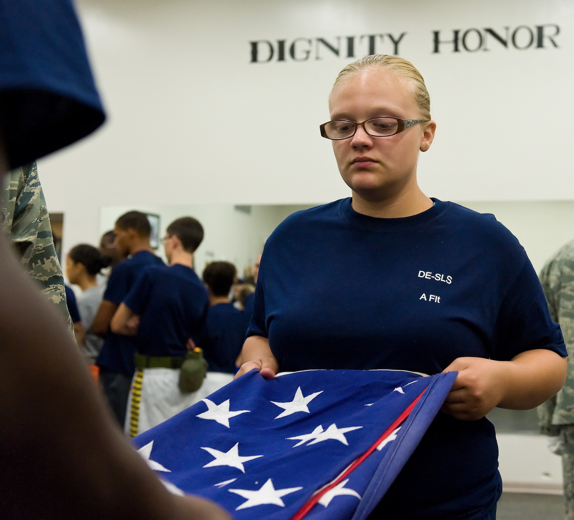 Air Force junior ROTC cadet Jessica Brielia, Dover High School, Dover, Del., folds the U.S. flag June 18, 2014, at Dover Air Force Base, Del. Brielia and 73 other cadets from five Delaware high schools toured the base as part of a junior ROTC summer leadership school. (U.S. Air Force photo/Roland Balik)