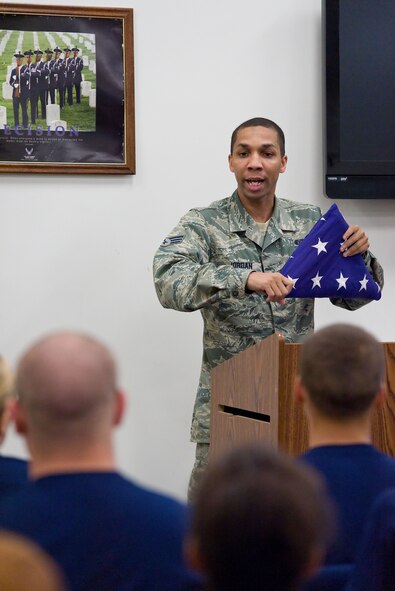 Senior Airman Paul Jordan, Dover Air Force Base honor guard member, instructs Air Force junior ROTC cadets on U.S. flag folding June 18, 2014, at Dover AFB, Del. The cadets toured numerous facilities on base over a three-day period. (U.S. Air Force photo/Roland Balik)