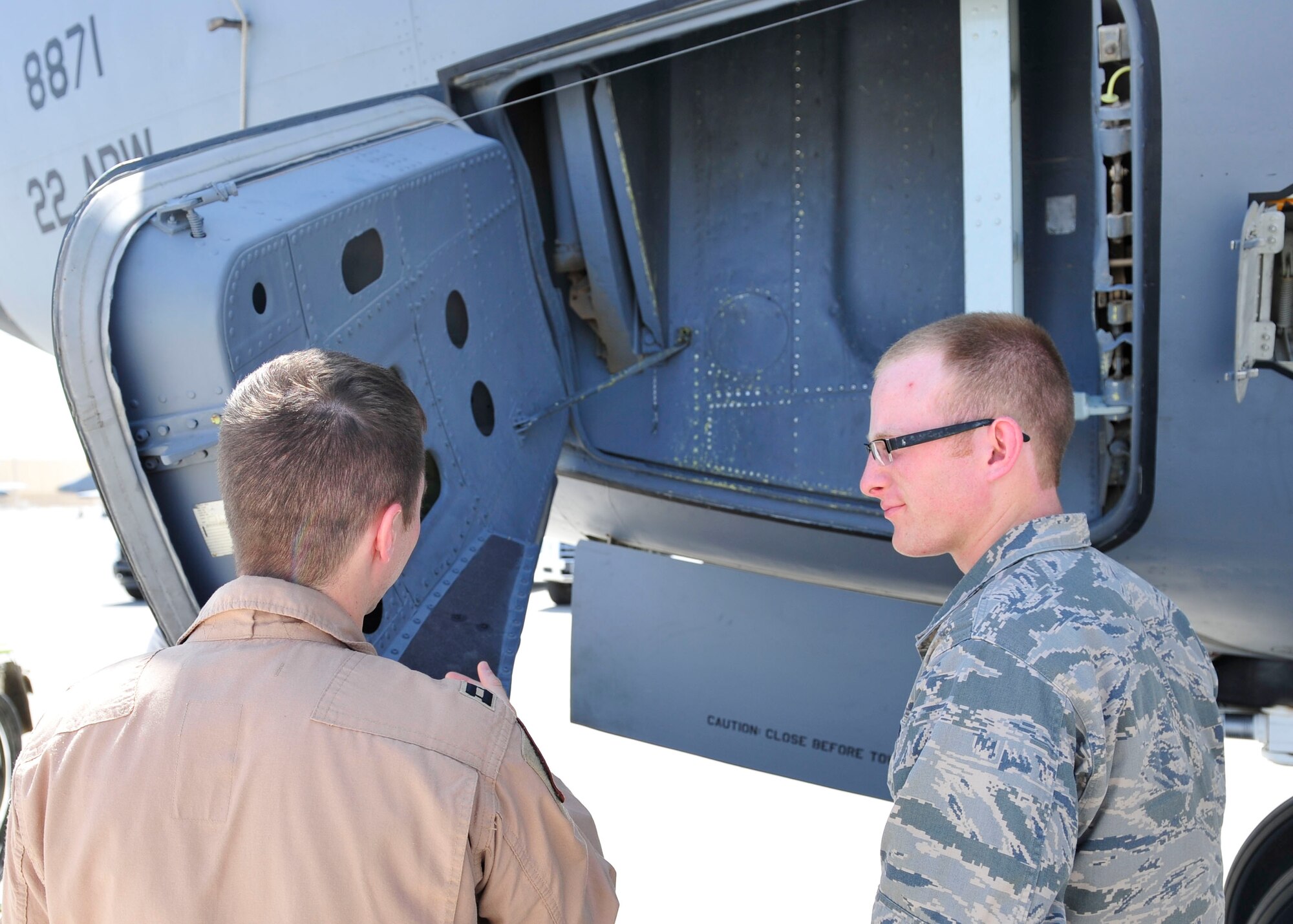 U.S. Air Force Capt. Gregory Jemo, 340th Air Refueling Squadron KC-135 pilot explains the emergency door function on a KC-135 Stratotanker to a U.S. Air Force Academy cadet at Al Udeid Air Base, Qatar, June 16, 2014. Cadets visited AUAB  as part of a Air Force program to shadow officers and enlisted members to experience the active duty lifestyle. Gallasher is deployed from MacDill Air Force Base, Florida. (U.S. Air Force photo by Senior Airman Colin Cates)