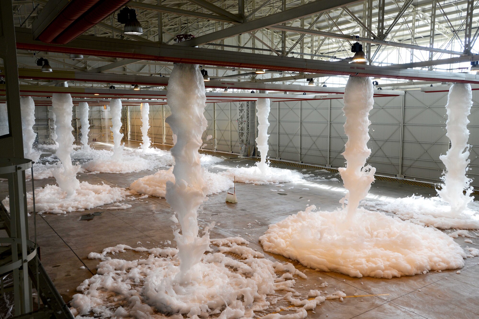 Foam from high-expansion foam generators falls to the ground in Hangar 1 during a systems check, June 18, 2014, at Aviano Air Base, Italy. In the event of a fire, the foam works to separate the flame source from the fuel surface and then begins to cool the fuel and surrounding metal surfaces for recovery. (U.S. Air Force photo/Airman 1st Class Deana Heitzman)