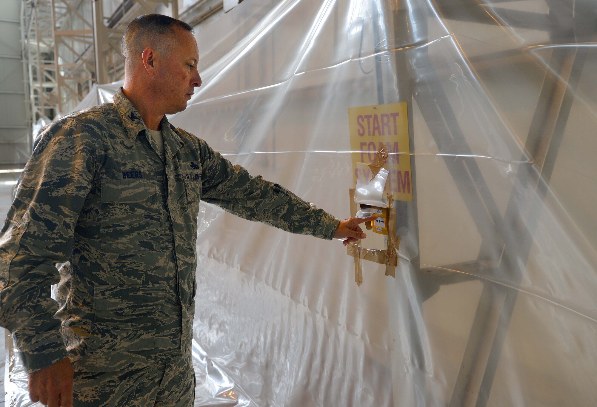 Col. Brian Beers, 31st Maintenance Group commander, activates the fire suppressor system in Hangar 1 during a systems test, June 18, 2014, at Aviano Air Base, Italy. Fire suppression systems using high-expansion foam are designed to control fires quickly while decreasing the amount of damage to aircraft, equipment and other materials. (U.S. Air Force photo/Airman 1st Class Deana Heitzman) 