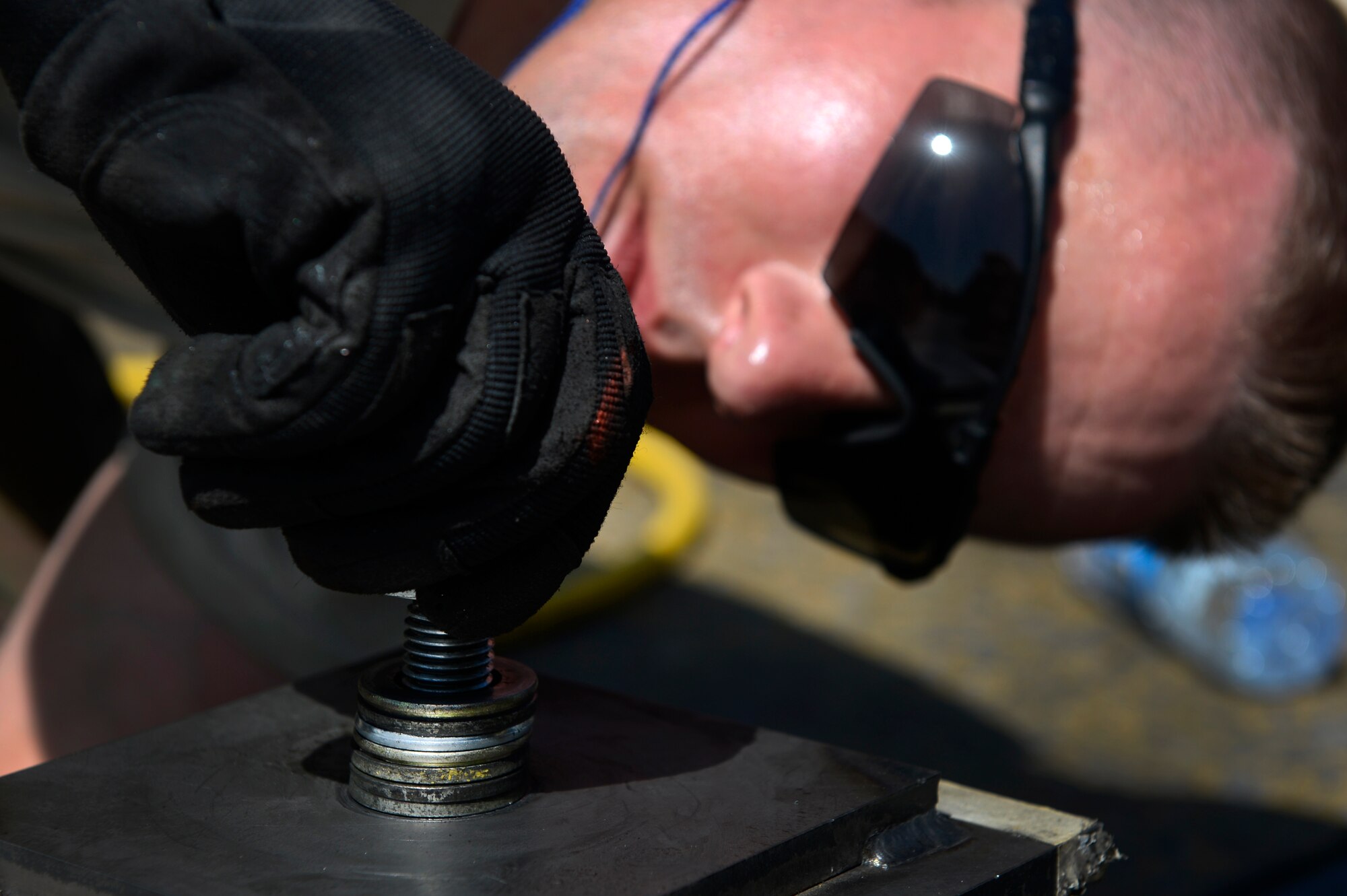 U.S. Air Force Master Sgt. Ken Safe, 455th Expeditionary Civil Engineer Squadron, tightens down a bolt on a polly pad on the flightline at Bagram Airfield, Afghanistan June 5, 2014. Each polly pad consists of 248 bolts. Safe, a Portland, Ore. native is deployed from the 142nd  Fighter Wing Portland Air National Guard Base, Ore. (U.S. Air Force photo by Senior Airman Sandra Welch)