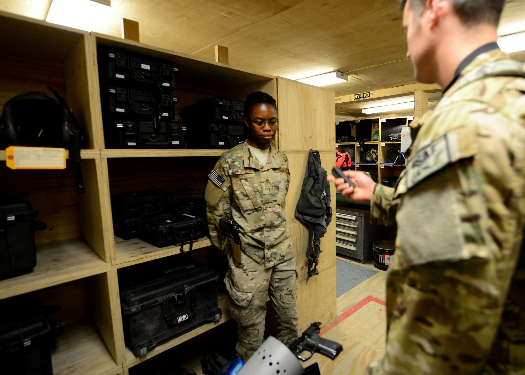 U.S. Air Force Staff Sgt. Nancy Kendrick, 774th Expeditionary Airlift Squadron aircrew flight equipment non-commissioned officer-in-charge performs a weapons check for a pilot at Bagram Airfield, Afghanistan June 18, 2014. As part of aircrew flight equipment, Kendrick performs maintenance on all aircrew equipment, trains aircrew on equipment use and inspects their weapons before and after every mission. Kendrick is deployed from Dyess Air Force Base, Texas and a native of Philadelphia, Pa.  (U.S. Air Force photo by Staff Sgt. Evelyn Chavez/Released)