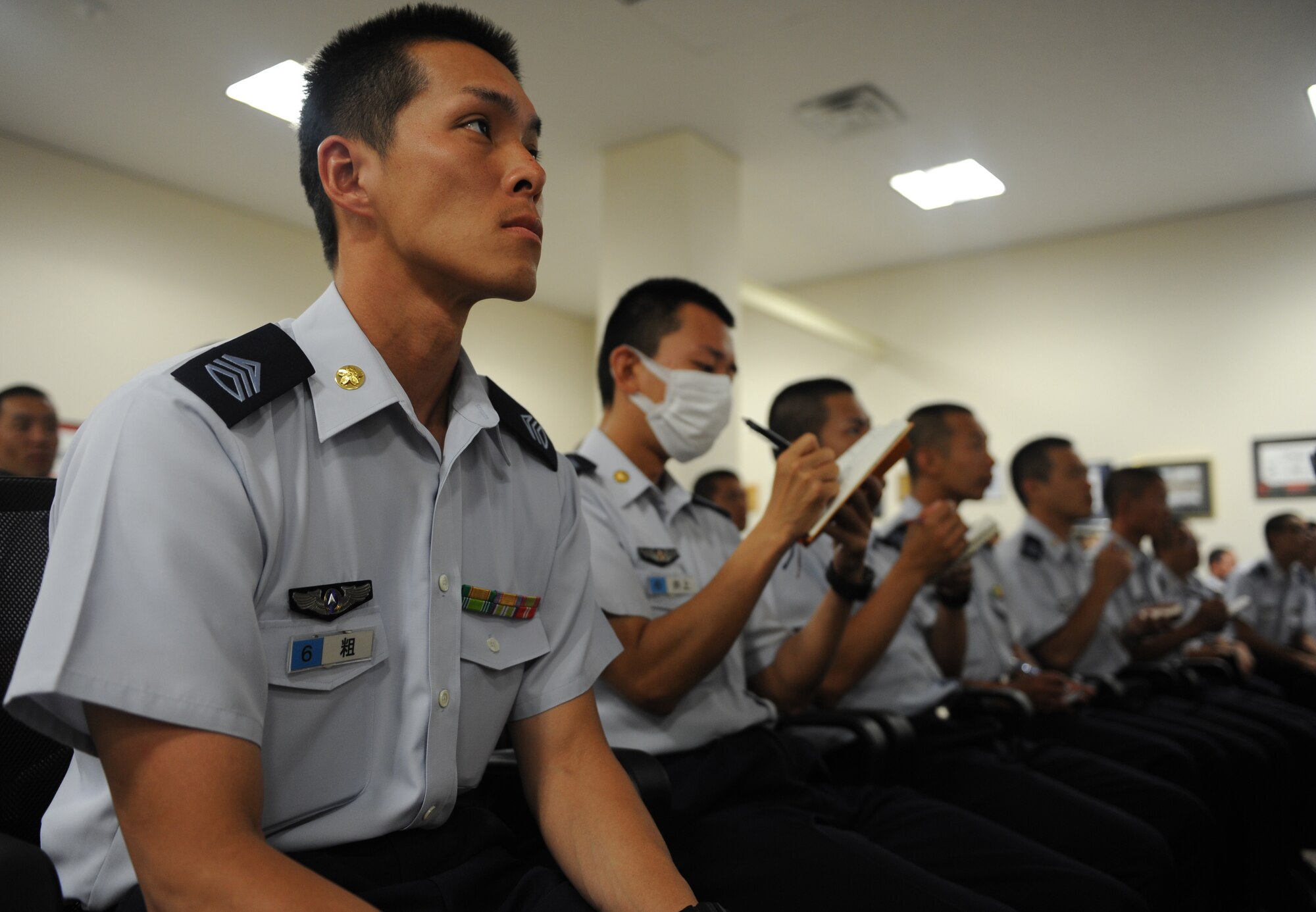 Members of the Japan Air Self Defense Force listen to a speaker during an orientation mission briefing on Kadena Air Base, Japan, June 19, 2014. The JASDF members toured the 909th Air Refueling Squadron and a KC-135 Stratotanker to learn more about its mission, capabilities, and operation. (U.S. Air Force photo by Airman 1st Class Keith James)