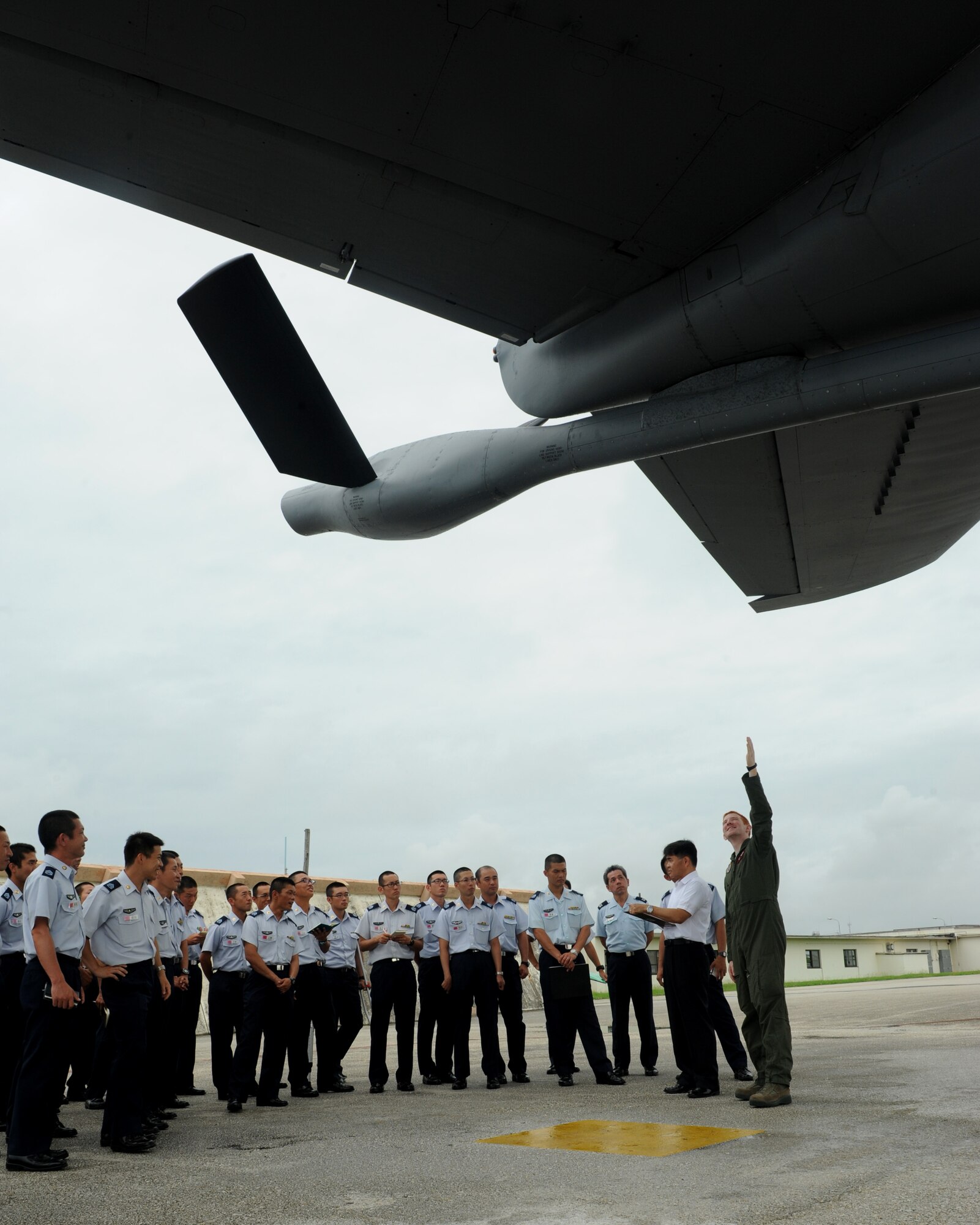 U.S. Air Force Airman 1st Class Eric Severs, 909th Air Refueling Squadron boom operator, informs Japan Air Self Defense Force members of the capabilities of a KC-135 Stratotanker on the flightline of Kadena Air Base, Japan, June 19, 2014. During this tour, JASDF visited the 909th ARS aircraft to learn more about the refuelers' mission, capabilities, and operation. (U.S. Air Force photo by Airman 1st Class Keith James)