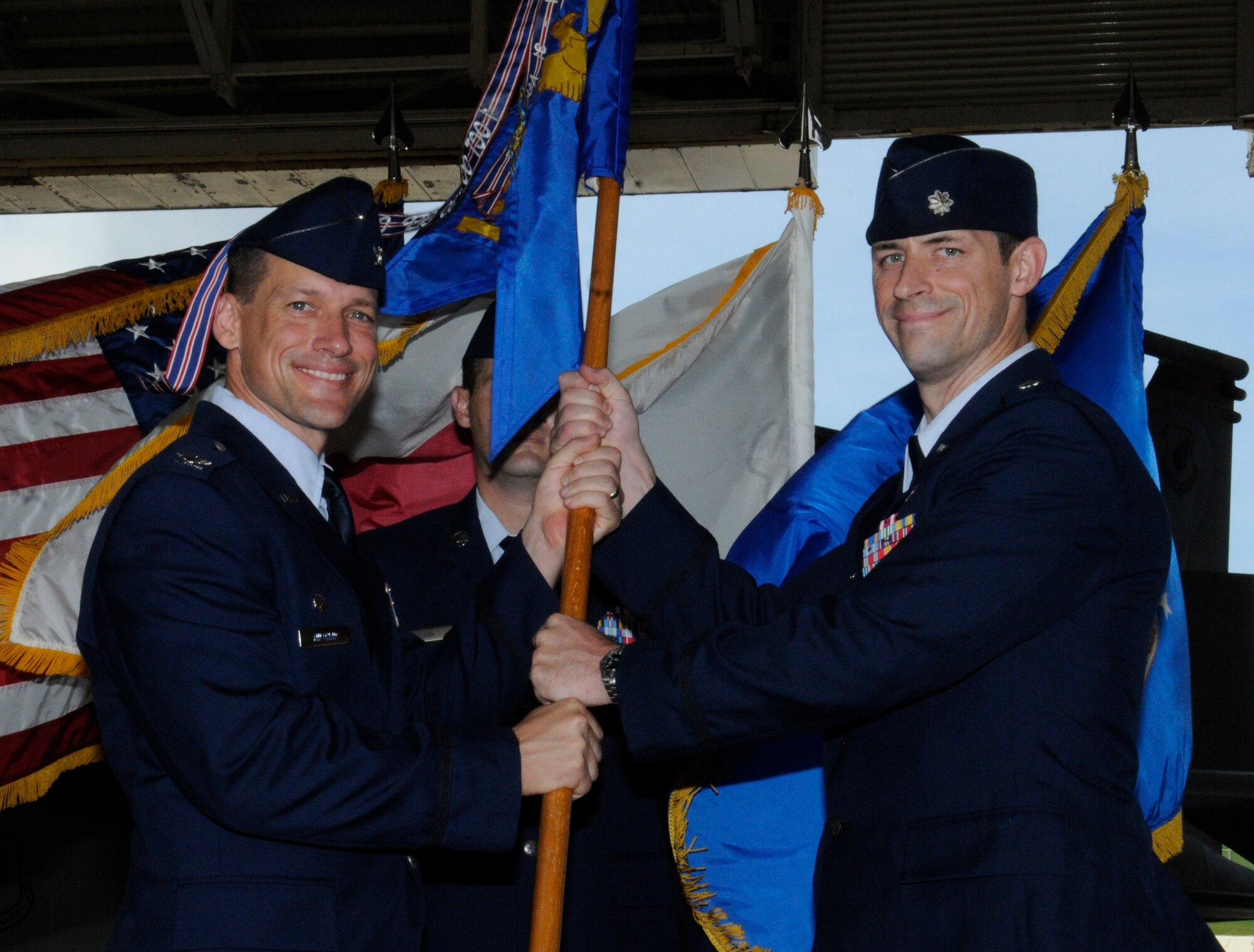 U.S. Air Force Col. Peter Milohnic, 18th Operations Group commander, passes the 18th Operations Support Squadron guidon to Lt. Col. Jack Arthaud, 18th OSS commander, during the 18th OSS change of command ceremony on Kadena Air Base, Japan, June 20, 2014. Arthaud served as the Director of Operations here before taking command. The 18th OSS supports air superiority, radar surveillance, airborne refueling, airlift and air rescue forces for Pacific Command operational plans and headquarters-directed contingency operations. (U.S. Air Force photo by Airman 1st Class Keith James)