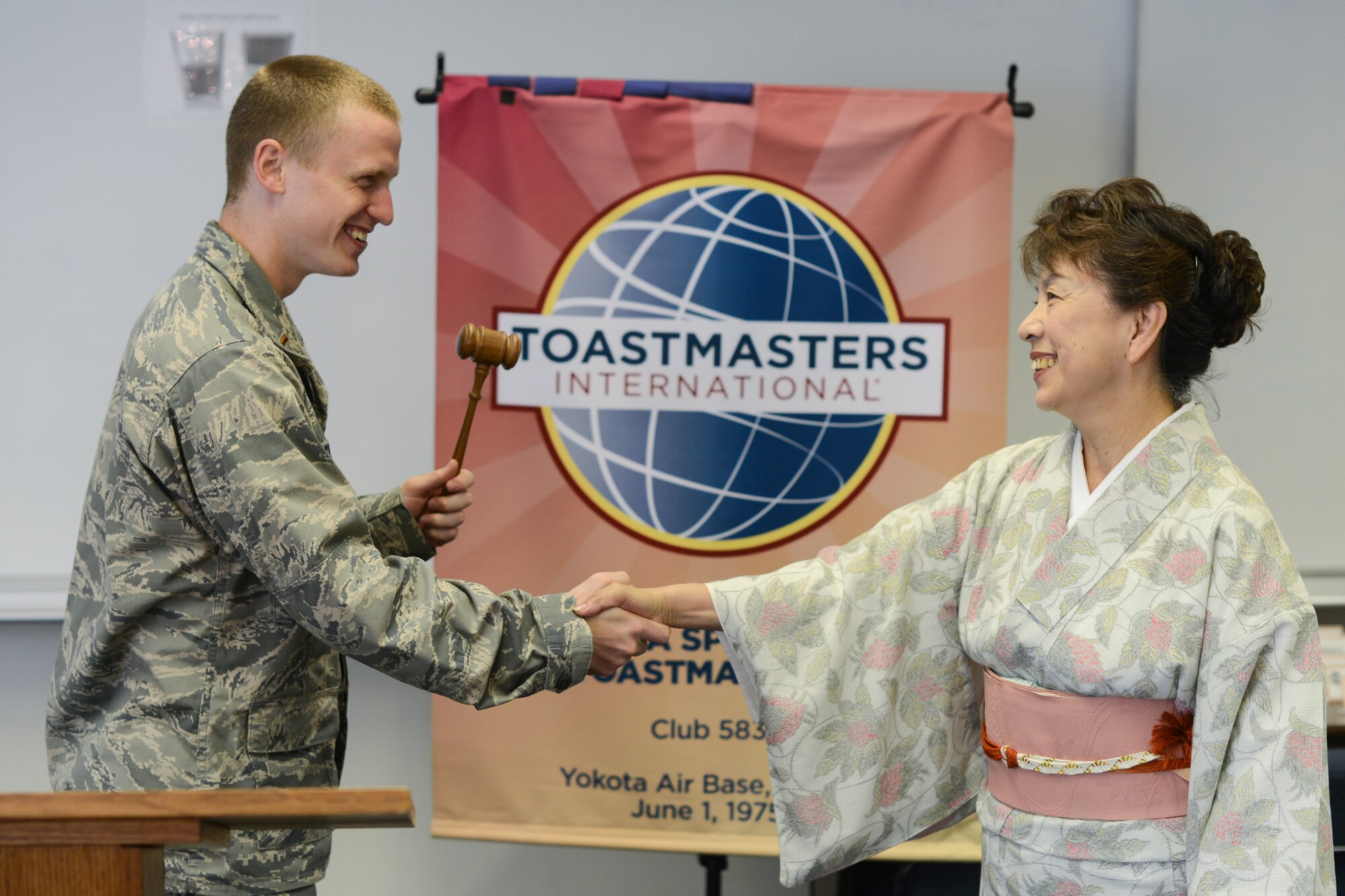 A member of the Fussa Speakers Toastermasters Club is greeted and introduced during a weekly meeting at Yokota Air Base, Japan, June 20, 2014. Each session, members give speeches as practice to improve techniques and gain experience. (U.S. Air Force photo by Staff Sgt. Cody H. Ramirez/Released)