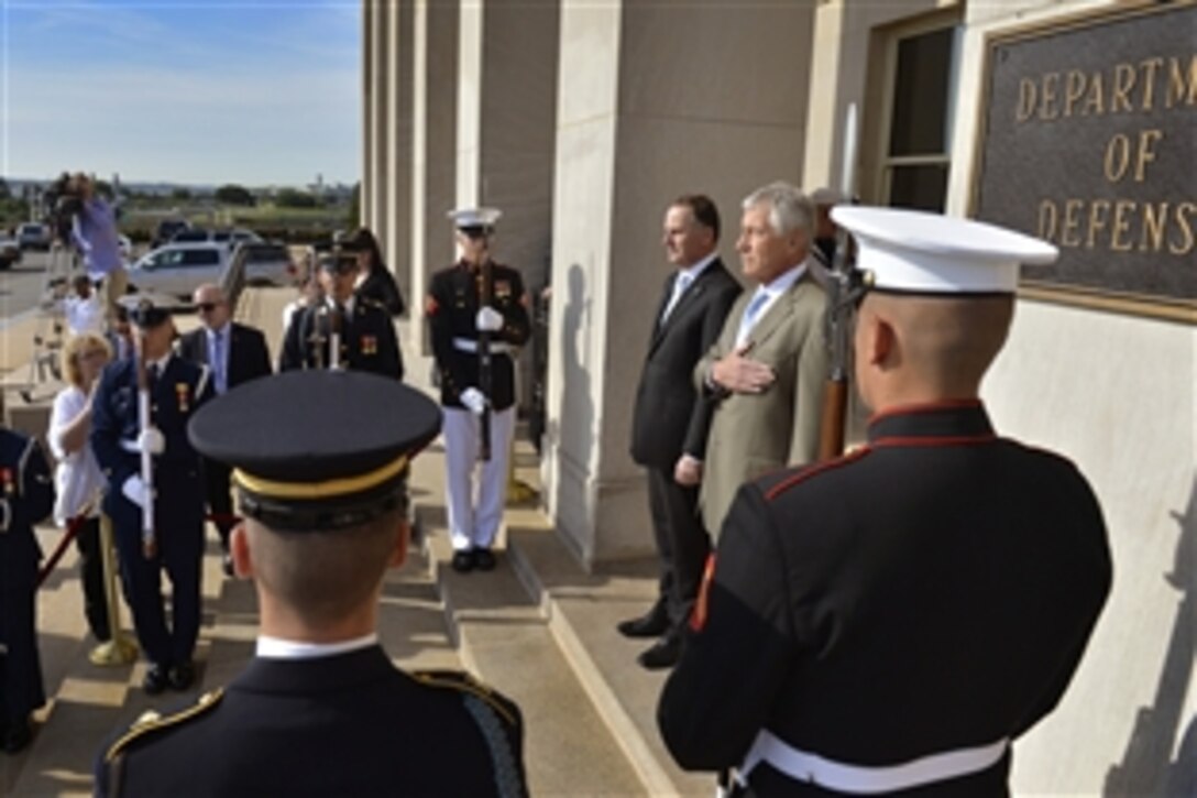 U.S. Defense Secretary Chuck Hagel, right, and New Zealand Prime Minister John Key pause during an honor cordon at the Pentagon, June 20, 2014. Hagel and Key later met to discuss mutual defense interests in the Asia-Pacific region.