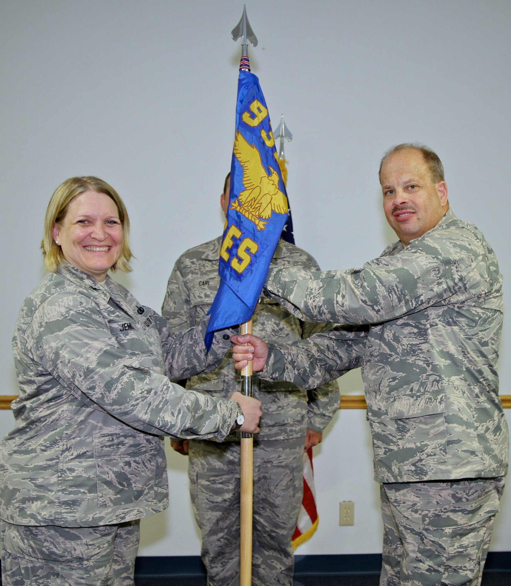 Lt. Col. Peter Weilbach takes the Civil Engineer Squadron's guidon from Col. Constance Jenkins, 932nd Mission Support Group commander.  The activity took place during Weilbach's Assumption of Command ceremony as the new commander for the Civil Engineering Squadron, June 21, 2014 at the CES auditorium, Scott Air Force Base.  (U.S. Air Force photo Tech. Sgt. Christopher Parr) 