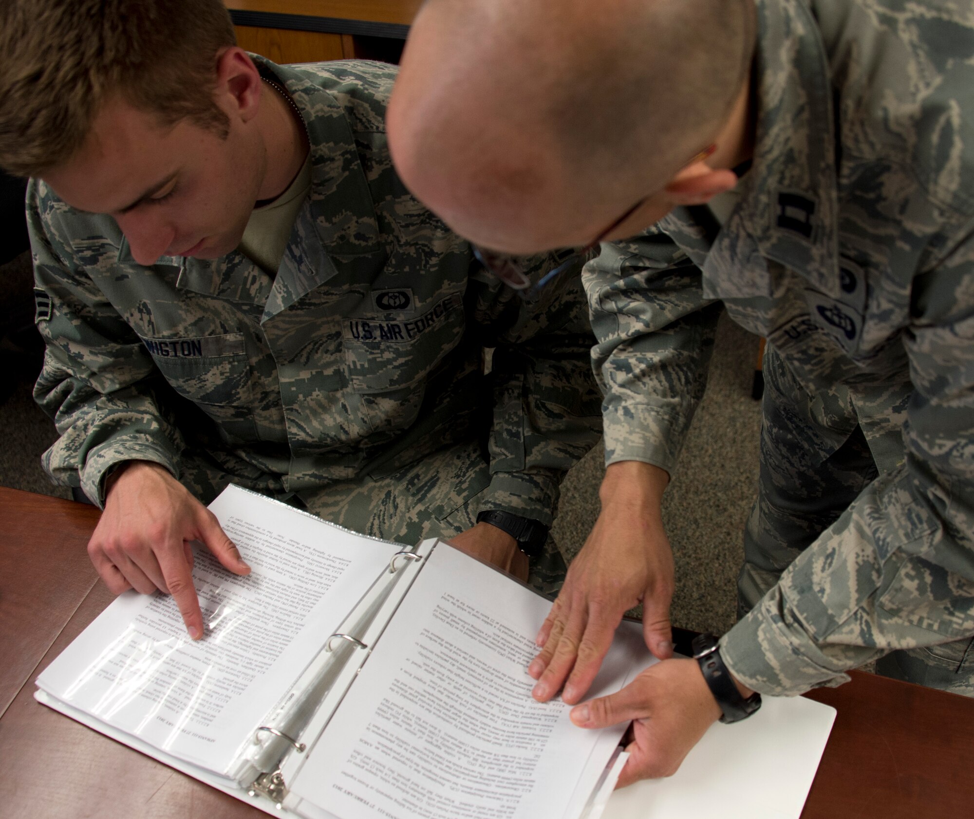 U.S. Air Force Capt. Allen Thill, right, assists Senior Airman Timothy Wigton with finding information in an Air Force Instruction manual in Little Falls, Minn., June 12, 2014. Wigton is in the last phase of his upgrade skill training during which he was evaluated on his knowledge of weather. 

(U.S. Air National Guard photo by Tech. Sgt. Amy M. Lovgren/Released)