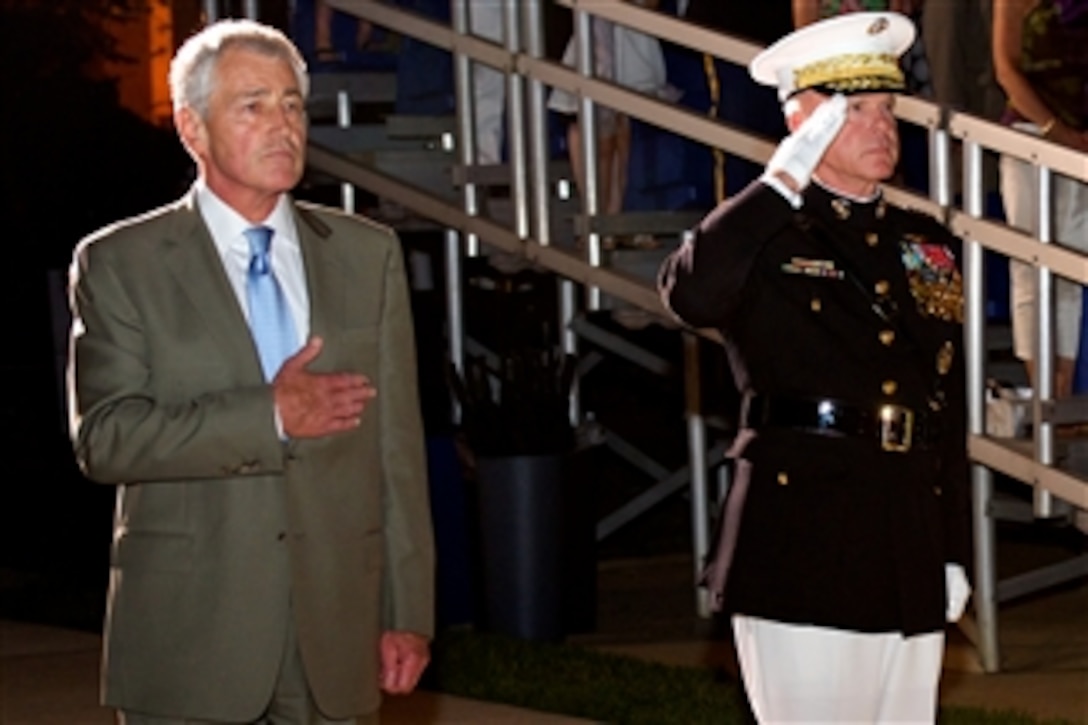 Defense Secretary Chuck Hagel and Marine Corps Commandant Gen. James F. Amos render honors near the end of a Friday evening parade at Marine Barracks Washington, D.C. June 20, 2014. 