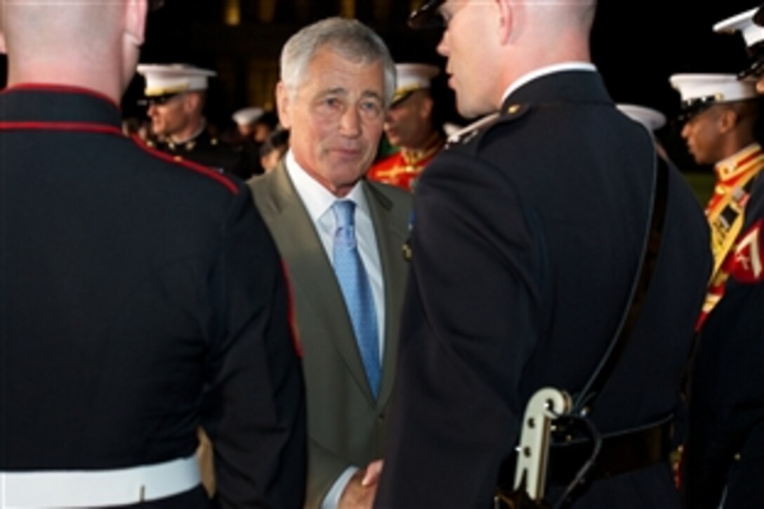Defense Secretary Chuck Hagel congratulates a member of the Marine Corps Silent Drill Platoon at a Friday evening parade at Marine Barracks Washington, D.C., June 20, 2014. 