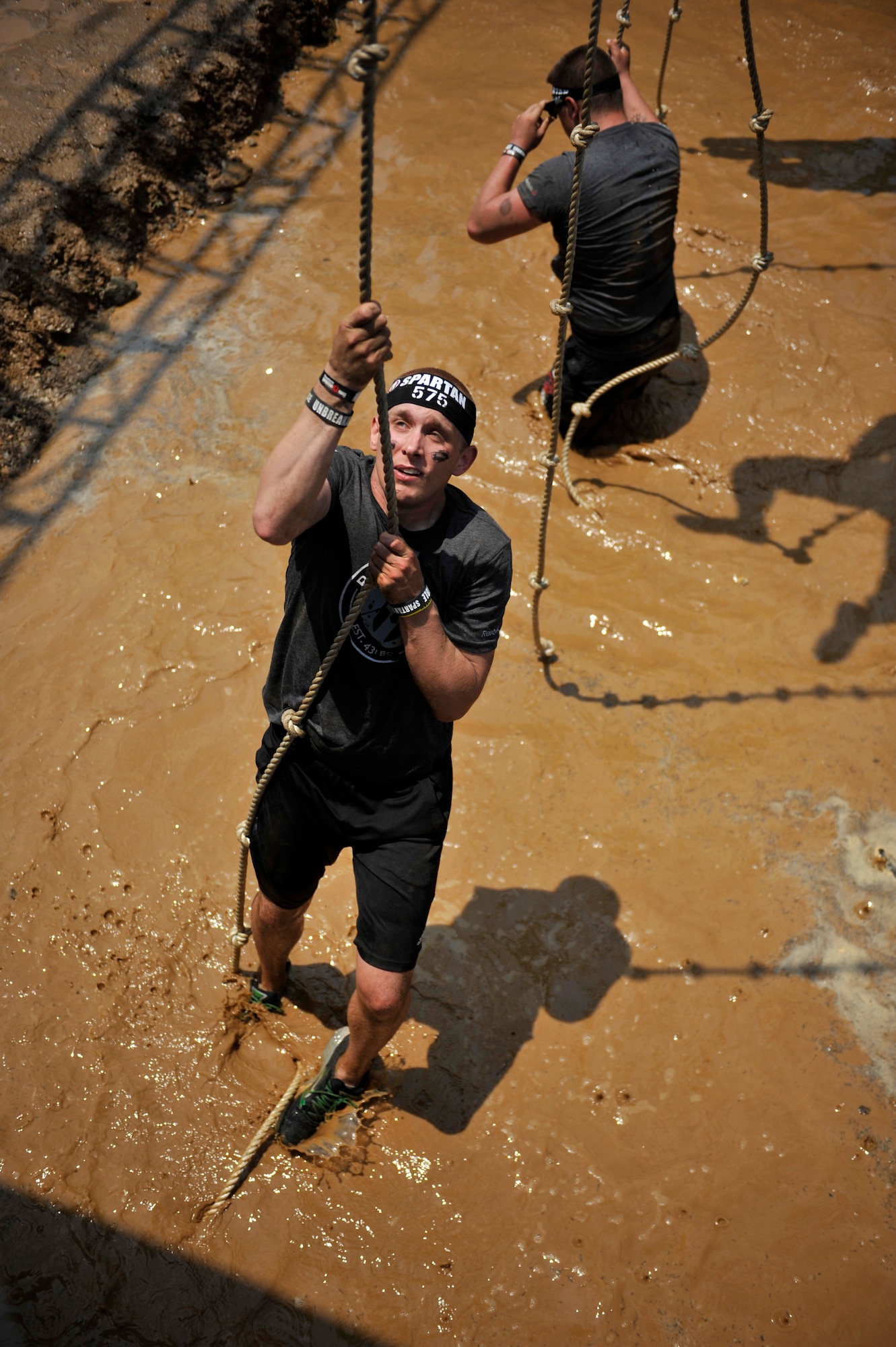 Airman 1st Class Zeke Garschagen, 51st Fighter Wing Judge Advocate military justice paralegal, goes up the rope climb obstacle during a Spartan Race in Seoul, Republic of Korea, June 15, 2014. To complete this obstacle, participants had to ring a bell at the top. (U.S. Air Force photo/Senior Airman David Owsianka)