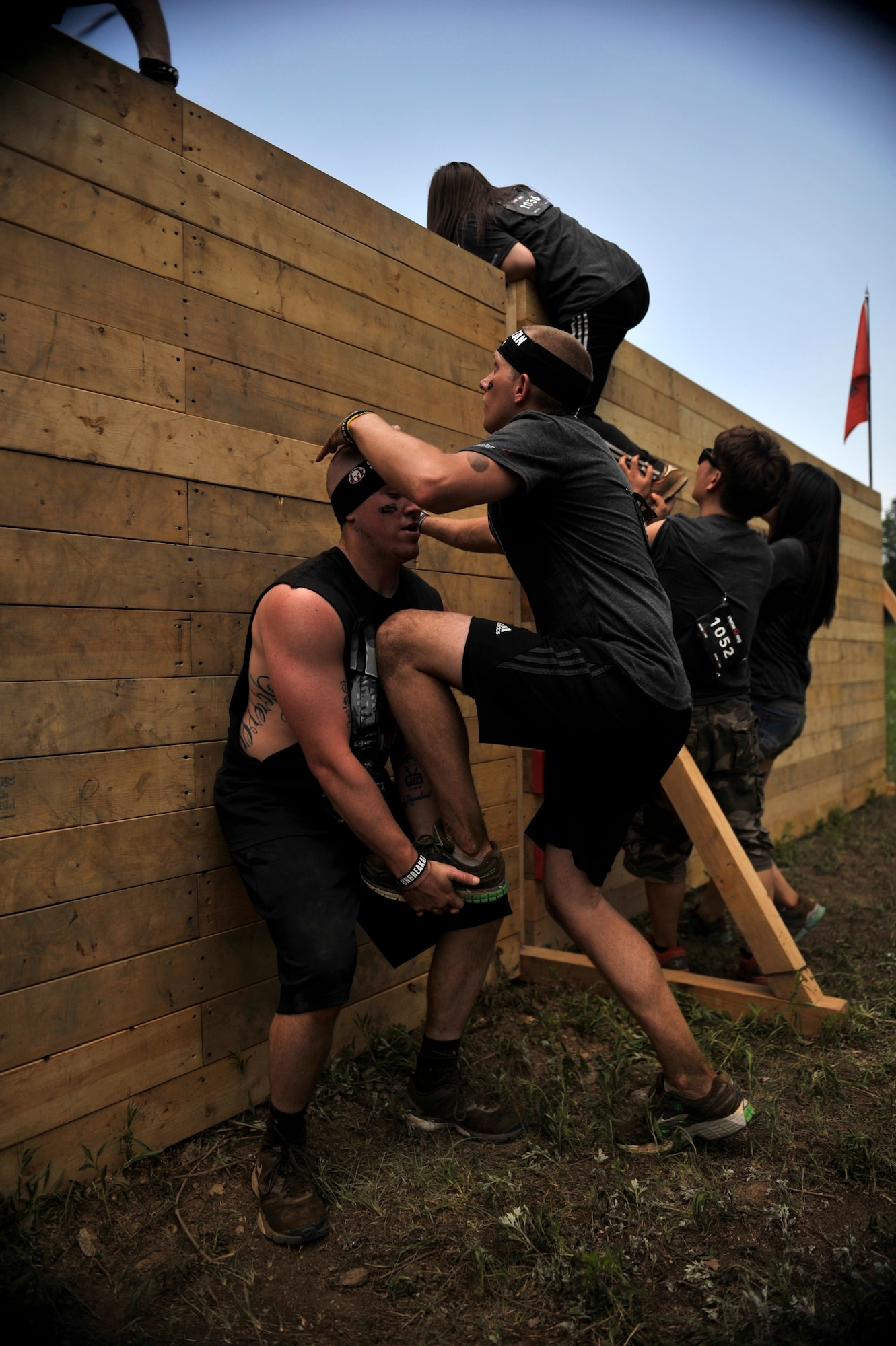 Airman 1st Class Kyle Harvey, 51st Comptroller Squadron, gives Airman 1st Class Zeke Garschagen, 51st Fighter Wing Judge Advocate military justice paralegal, a leg up over an 8-foot wall during a Spartan Race in Seoul, Republic of Korea, June 15, 2014. The walls ranged from 4 to –8 feet high. (U.S. Air Force photo/Senior Airman David Owsianka)