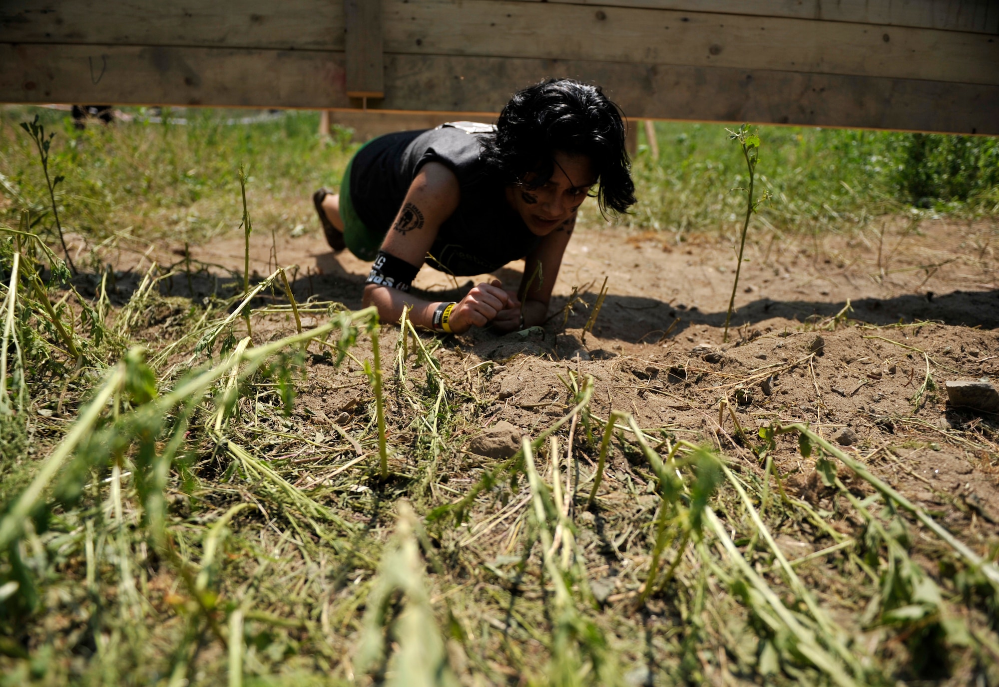 Airman 1st Class Lanalee Rogers, 51st Fighter Wing Command Post controller, crawls under a wall obstacle during a Spartan Race in Seoul, Republic of Korea, June 15, 2014. Participants had to perform 30 burpees if they did not complete an obstacle. (U.S. Air Force photo/Senior Airman David Owsianka)