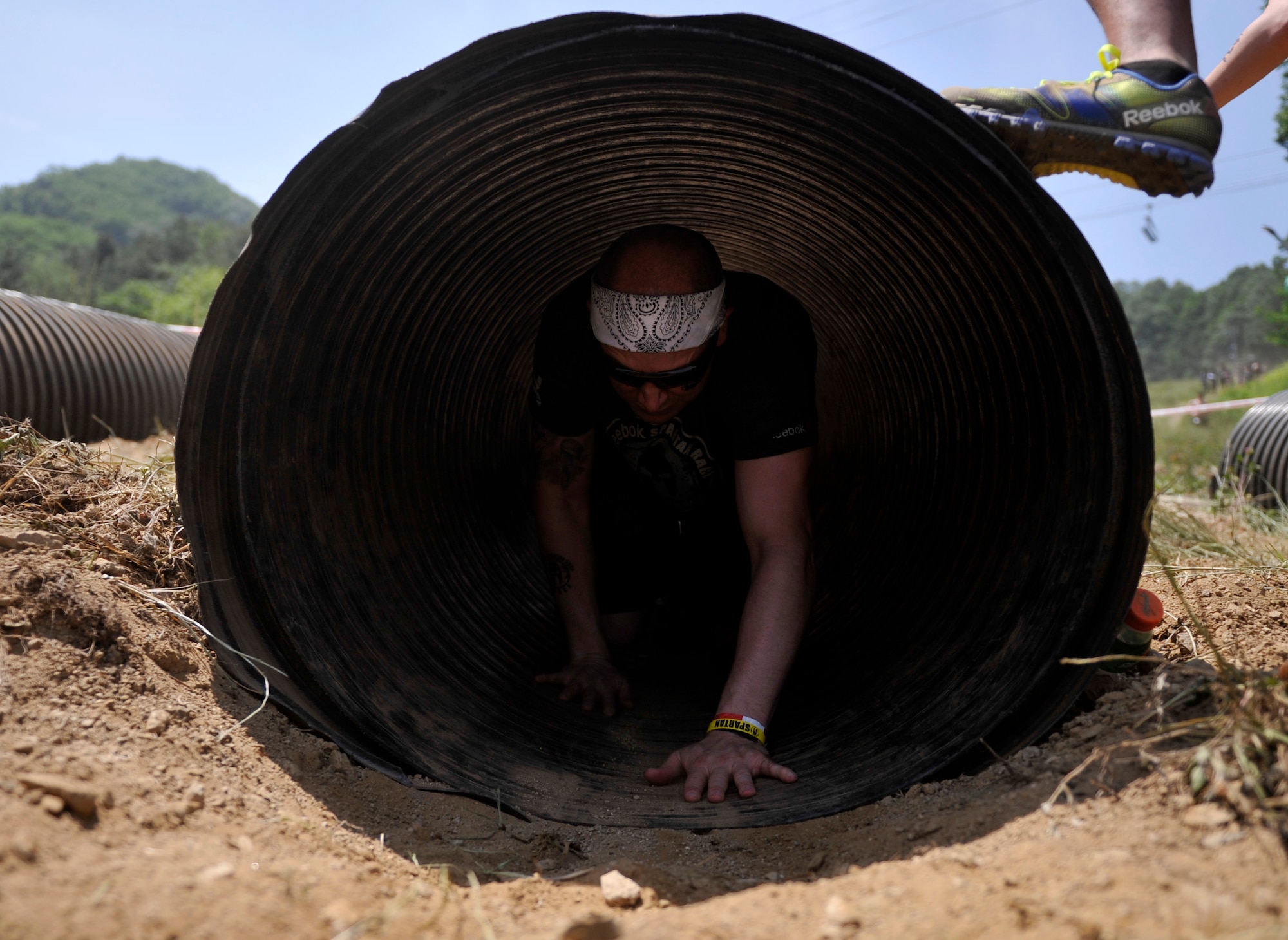 Tech. Sgt. Elliot Velez, 51st Fighter Wing Ground Safety NCO in charge, crawls through a tunnel obstacle during a Spartan Race in Seoul, Republic of Korea, June 15, 2014. There are four different types of Spartan Races: Spartan Sprint, Super Spartan, Spartan Beast and Ultra Beast. (U.S. Air Force photo/Senior Airman David Owsianka)
