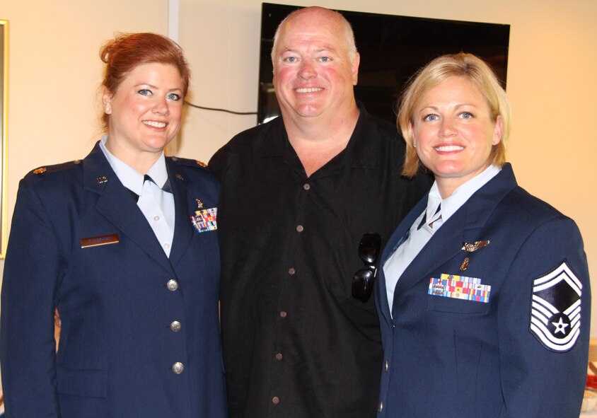 Maj. Rachelle Eckerman was pinned by her sister Senior Master Sgt. Heather Braundmeier and her father retired Maj. Joseph Eckerman, during her promotion ceremony. The ceremony was held at Cardinal Creek golf course on Scott Air Force Base during June unit training assembly. (U.S. Air Force photo/Staff Sgt. Meiko Schill.)