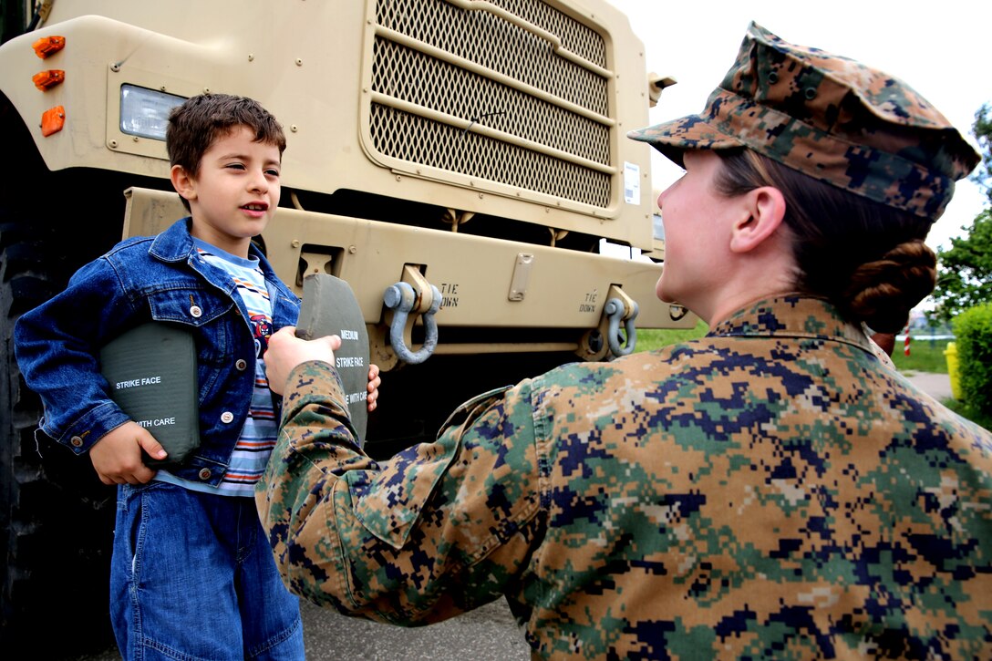First Lt. Melanie Helmer, the adjutant for Black Sea Rotational Force 14, from 3rd Battalion, 8th Marine Regiment, explains small arms protective insert plates to a child in Constanta, Romania during Children’s Day weekend with the community May 31, 2014. Marines and sailors participated in Romania’s Children’s Day with a showcase of standard-issued equipment and military vehicles for children to interact with first-hand. The observation promotes mutual exchange and understanding among children while encouraging actions to benefit and promote the welfare of the nation’s children. (Official Marine Corps photo by Lance Cpl. Scott W. Whiting, BSRF PAO/ Released)