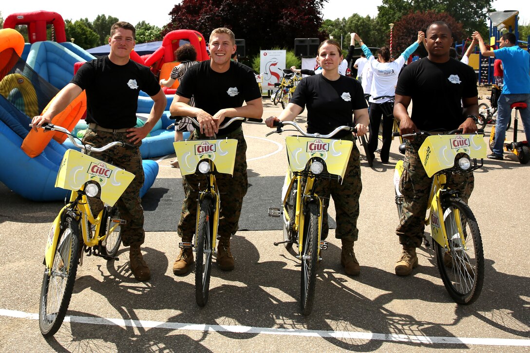 (Left to right) Lance Cpl. Evan Johnson, Navy Petty Officer 3rd Class Christopher Bowlin, 1st Lt. Melanie Helmer and Lance Cpl. Devon Jones, service members with Black Sea Rotational Force 14, from 3rd Battalion, 8th Marine Regiment, pose for a picture after participating in a children’s bicycle marathon while Marines and sailors visited a local park in Constanta, Romania during Children’s Day weekend with the community May 31, 2014. Marines and sailors participated in Romania’s Children’s Day with a showcase of standard-issued equipment and military vehicles for children to interact with first-hand. The observation promotes mutual exchange and understanding among children while encouraging actions to benefit and promote the welfare of the nation’s children. (Official Marine Corps photo by Lance Cpl. Scott W. Whiting, BSRF PAO/ Released)
