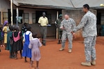 Army Sgt. Enrique Icedo (right) and Army 1st Lt. Victor Lauersdorf, members of Task Force Raptor, 3rd Squadron, 124th Cavalry Regiment, Texas Army National Guard, visit a local school near the Ugandan Peoples Defense Forces training center here April 3, 2012. The Guard members are conducting various military-to-military training sessions in support of Combined Joint Task Force-Horn of Africa, whose mission is to build partnerships with nations in East Africa.