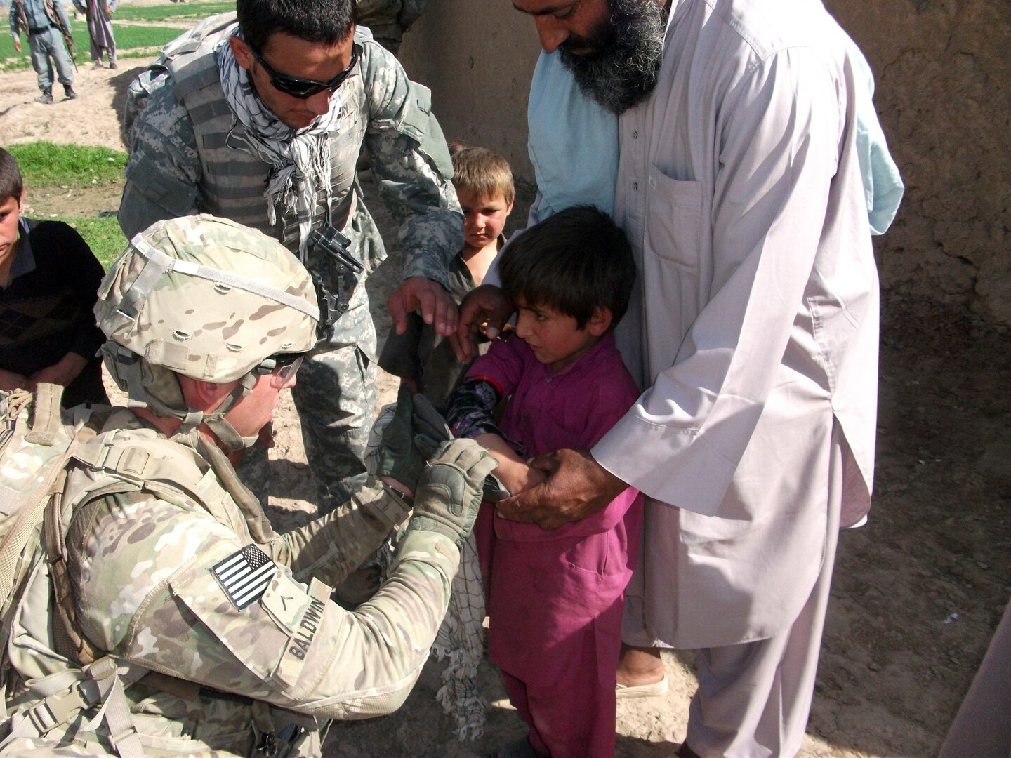 Army Pvt. Eric Baldwin, a medic assigned to Company A, 1st Battalion, 125th Infantry Regiment, 37th Infantry Brigade Combat Team, applies a splint to the arm of an Afghan boy March 23, 2012, as his father holds him still. The Soldiers noticed the boy had an injured arm while conducting a patrol in the Gor Teppa area of Kunduz province, Afghanistan, with the Afghan National Police. The 37th IBCT is deployed to northern Afghanistan in support of the International Security Assistance Force in an effort to build ANP capacity.