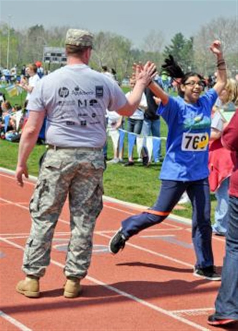 Army National Guard Staff Sgt. Shawn Rouvre, a human resources sergeant form the Pennsylvania National Guard, congratulates 15-year-old Jocelyn Nava as she finishes first in a 400-meter run during the Special Olympics Area M Games at Messiah College in Grantham, Pa., April 19, 2012.