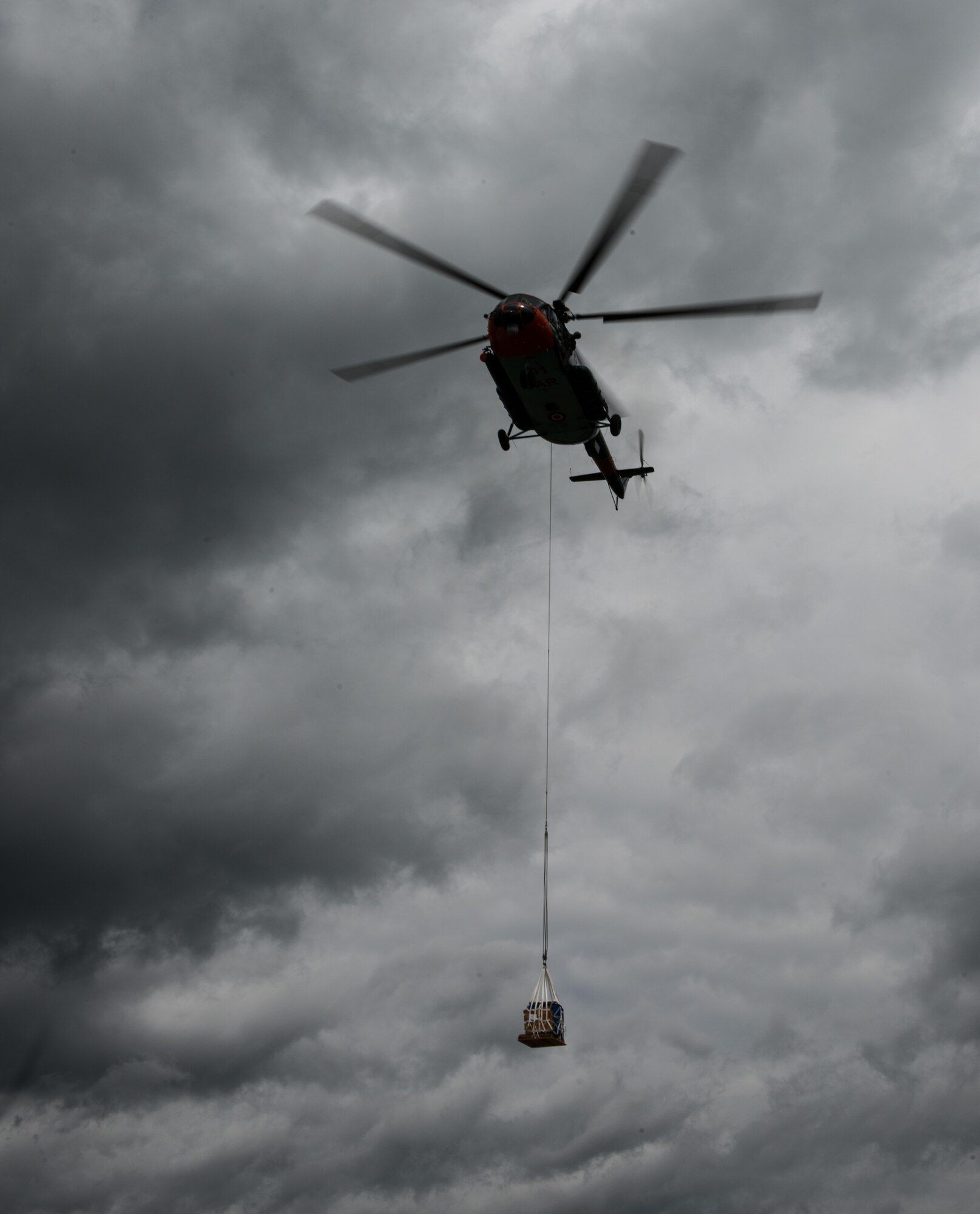 A Latvian Mi-8 helicopter flies off after Airmen from the 435th Contingency Response Group attached a bundle in part of sling-load operations training during the Air Force-specific portion of Saber Strike June 17, 2014, on Lielvarde Air Base, Latvia. During the final week of Saber Strike 2014 the 435th CRG, in conjunction with the 37th Airlift Squadron, trained on the full capabilities to open the Latvian air base. They also trained with Latvian and Estonian service members on airfield operations, command and control of air and space forces, weather support, and protection of operational forces, aircraft maintenance, and aerial port services. (U.S. Air Force photo/Senior Airman Jonathan Stefanko)