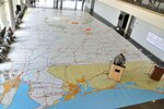 Alabama Guard members brief hurricane plans April 28, 2012, on a spanned map that measuring 40 feet wide and 85 feet long.