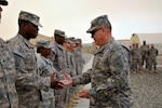Army Lt. Gen. William Ingram Jr., the director of the Army National Guard, presents a National Guard coin of excellence to Army Sgt. Ferrell Reynolds of the North Carolina National Guard's 1452nd Transportation Company. The trip gave Ingram the opportunity to visit and talk with guardsmen and to see for himself the health and welfare of Army National Guard soldiers in Kuwait.