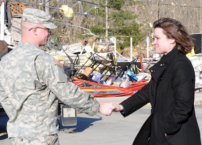 Army Spc. Matthew Sellers, Horizontal Engineer for the 207th Engineer Battalion, based in Hazard, Ky., shakes hands with Kenna Spears, district leader for Advance Auto Parts in Salyersville, Ky., March 3, 2012. Kentucky National Guard members from Hazard assisted local residents by directing traffic, aiding in search and rescue missions, and handing out supplies.